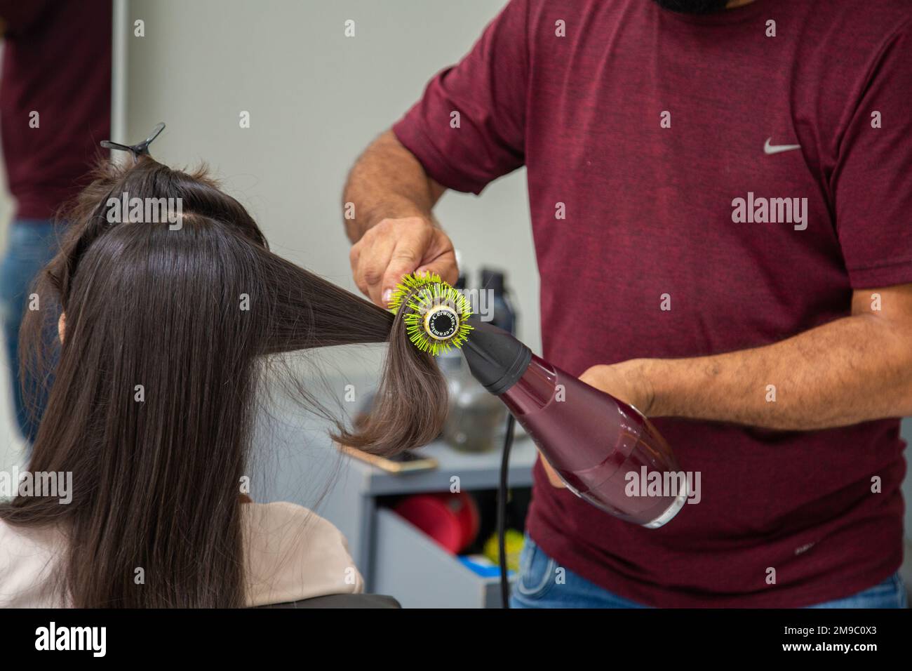 Goiania, Goiás, Brasilien – 10. Januar 2023: Detail eines Friseursalons mit Bürste und Trockner, Bürsten und Trocknen der Haare eines Kunden. Stockfoto