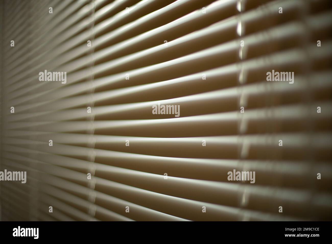 Jalousien im Büro. Details zur Innenausstattung. Das Fenster ist vor Licht geschlossen. Schutz vor scharfem Sonnenlicht. Jalousien am Fenster. Stockfoto
