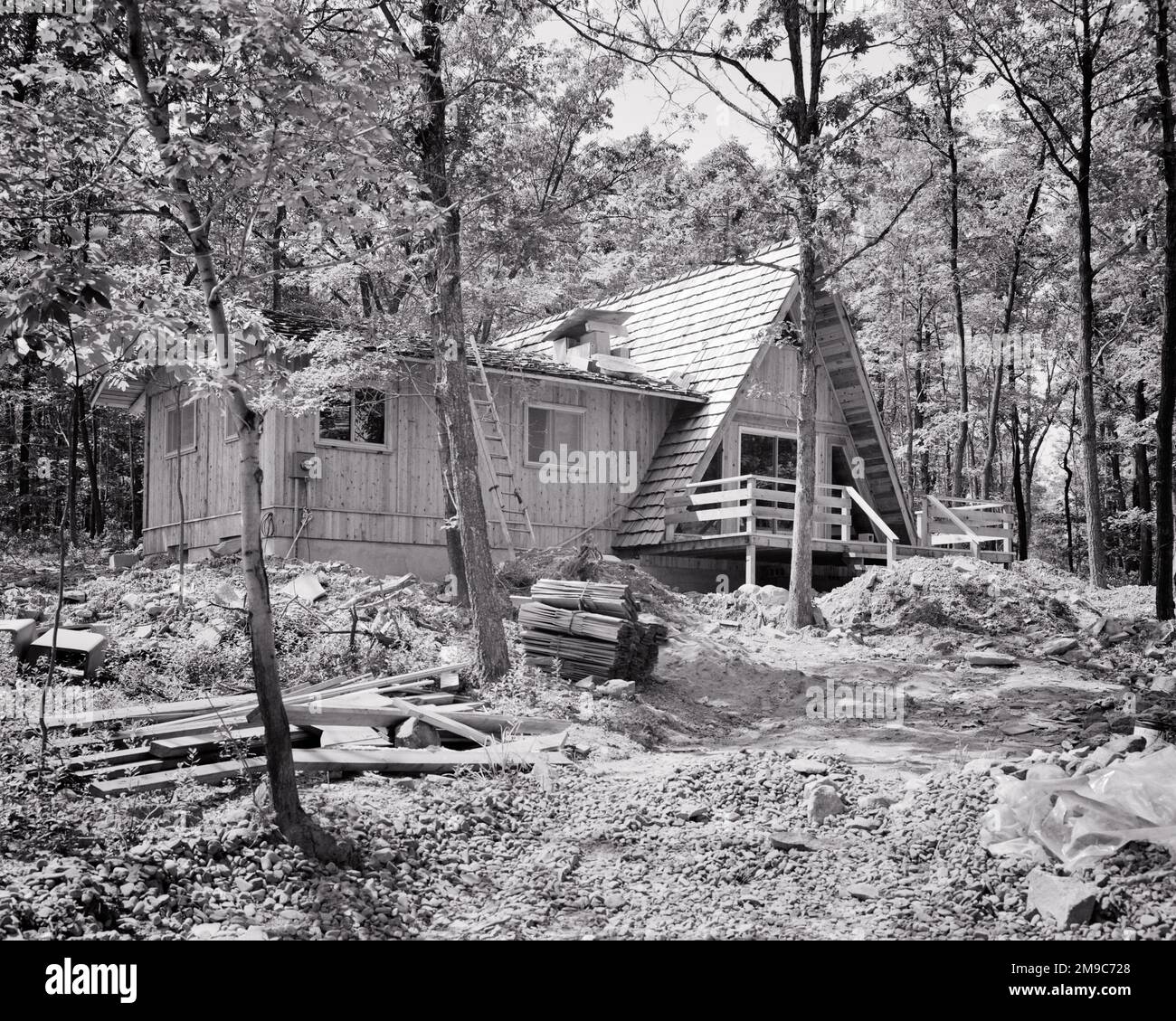 1970S A-RAHMEN-HAUS MIT ZUSATZ IN BEWALDETER GEGEND IN POCONO MTS PA USA - B24041 HAR001 HARS POCONO IMMOBILIEN COMMONWEALTH-STRUKTUREN HINZUGEFÜGT KEYSTONE STATE RESIDENZ A-RAHMEN GEBÄUDE BEWALDETE KREATIVITÄT ENTSPANNUNG WÄHREND DES BAUENS URLAUB SCHWARZ UND WEISS HAR001 ALTMODISCHE ZUFLUCHT Stockfoto