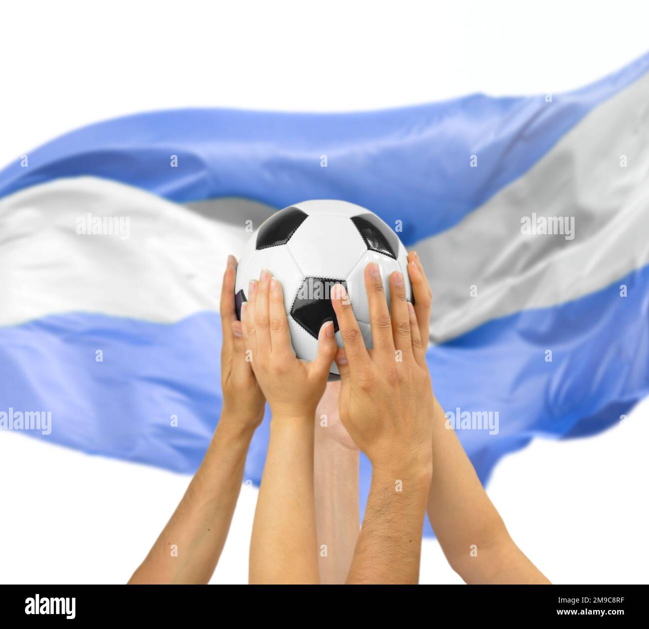 Eine Gruppe von Fußballspielern, die einen Fußball im Fußballstadion mit argentinischer Flagge halten Stockfoto