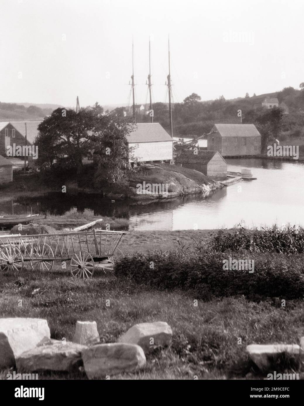 1920S MALERISCHE AUSSICHT, ALTER DREIMAST-ANGELN, SCHONER, WASSERZULAUF, HOLZFARM, HEUWAGEN, GROSSE STEINE BOOTHBAY HAFEN, MAINE, USA - L154 HAR001 HARS SCHONER-MAST, ENTSPANNUNG, SCHWARZ UND WEISS, HAR001 INLET, ALTMODISCH Stockfoto