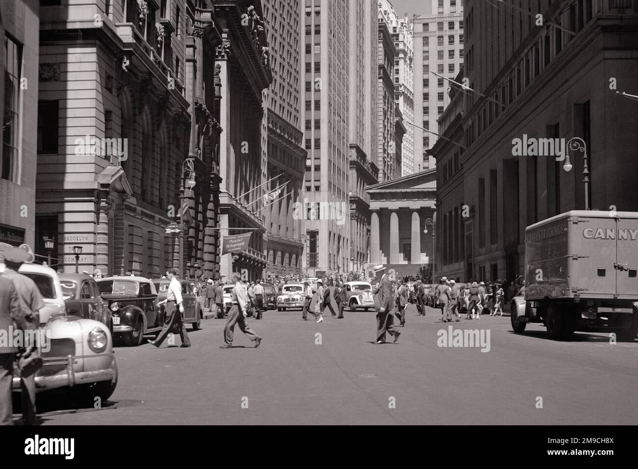 1940S AUTOS FUSSGÄNGER UND BLICK NACH NORDEN DIE BROAD STREET HINAUF ZUR FEDERAL HALL AN DER WALL STREET DOWNTOWN MANHATTAN NEW YORK CITY - Q41320 CPC001 HARS KOPIERRAUM VOLLE LÄNGE DAMEN PERSONEN VEREINIGTE STAATEN VON AMERIKA AUTO MÄNNER GEBÄUDE FUSSGÄNGER TRANSPORT B&W DOWNTOWN STRUCTURE ADVENTURE PROPERTY UND AUTOS SPANNUNG EXTERIEUR BREITE MÖGLICHKEITEN FÜR NYC IMMOBILIEN NEW YORK STRUCTURES AUTOS STÄDTE FAHRZEUGE GEBÄUDE NEW YORK CITY SCHWARZ-WEISS FEDERAL OLD FASHIONED Stockfoto