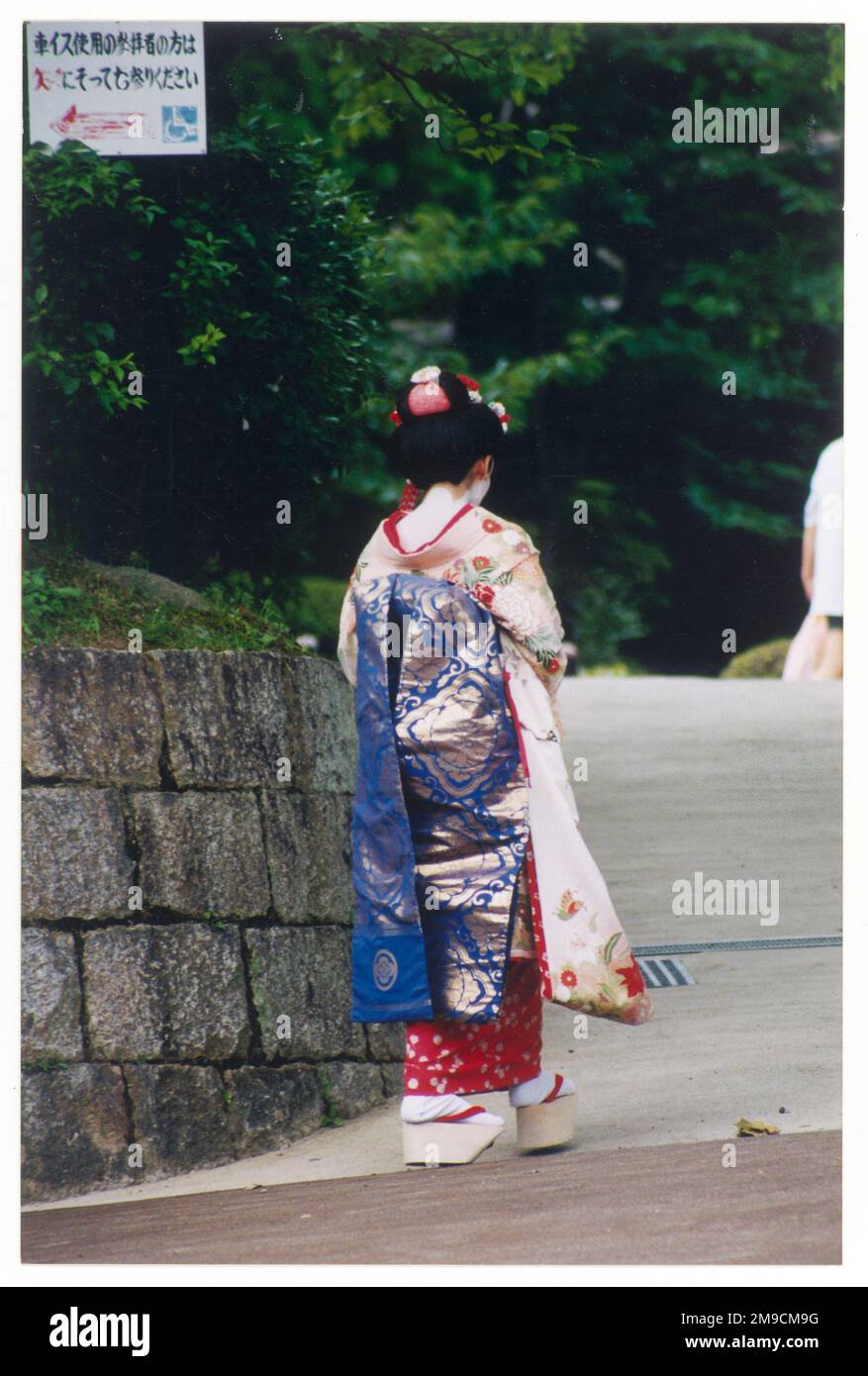 Geisha-Mädchen in traditionellem Kimono mit Blocksandalen. Stockfoto