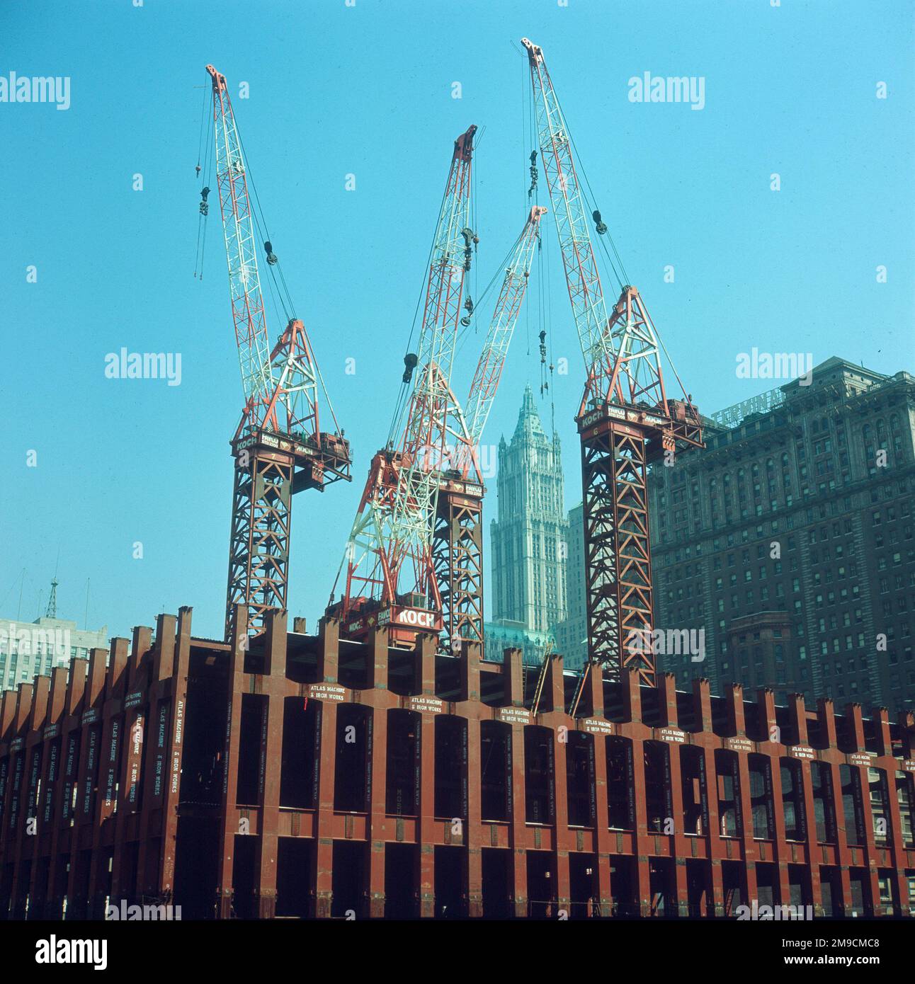Der Bau des World Trade Center in New York, die australischen Kräne im Kontrast zum alten Woolworth Building dahinter. Stockfoto
