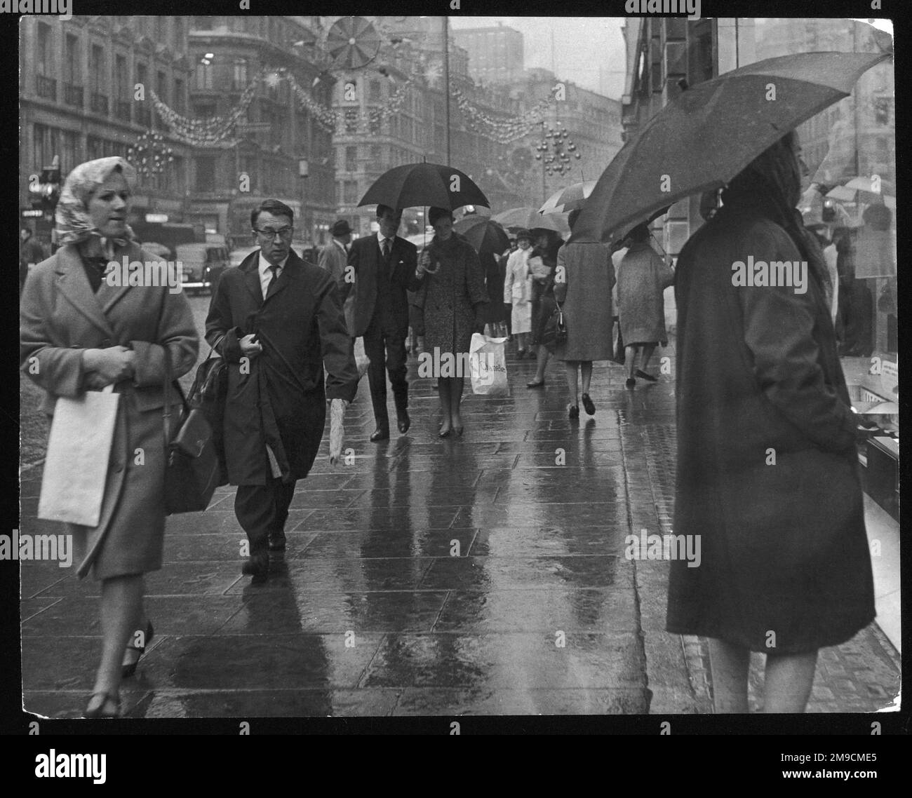 Weihnachtseinkäufer in der Regent Street, London, kaufen an einem schrecklich regnerischen Tag Geschenke. Stockfoto