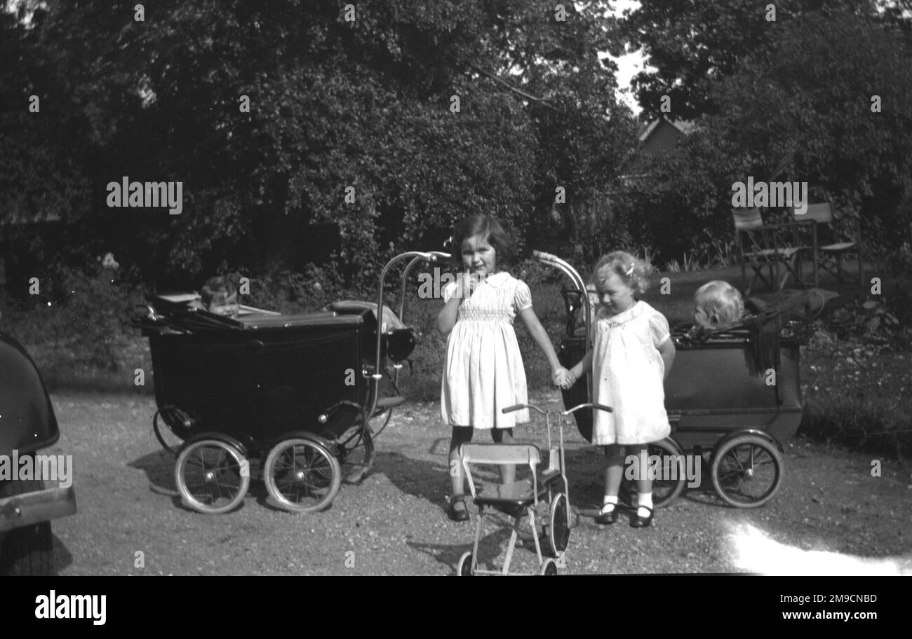 Zwei kleine Mädchen spielen mit Kinderwagen Stockfoto