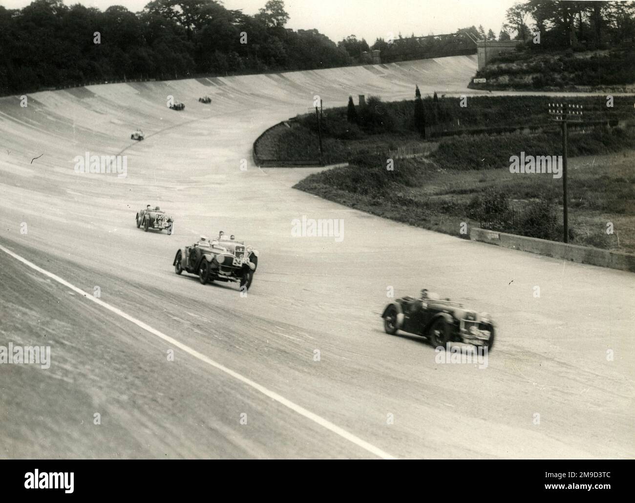 Cars 25, 24, 27 und 28 auf Members' Banking, Brooklands - JRH Baker fährt mit D Young (Car 26) MCC 8. High Speed Reliability Trial - 3. September 1932. Stockfoto