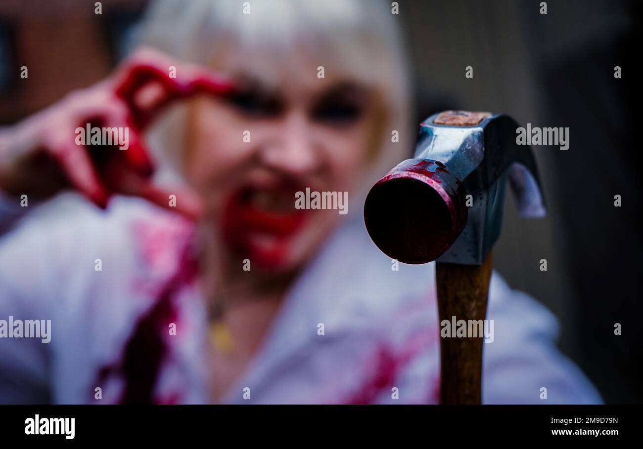 Weiße Frau mit einem blutigen Hammer Stockfoto