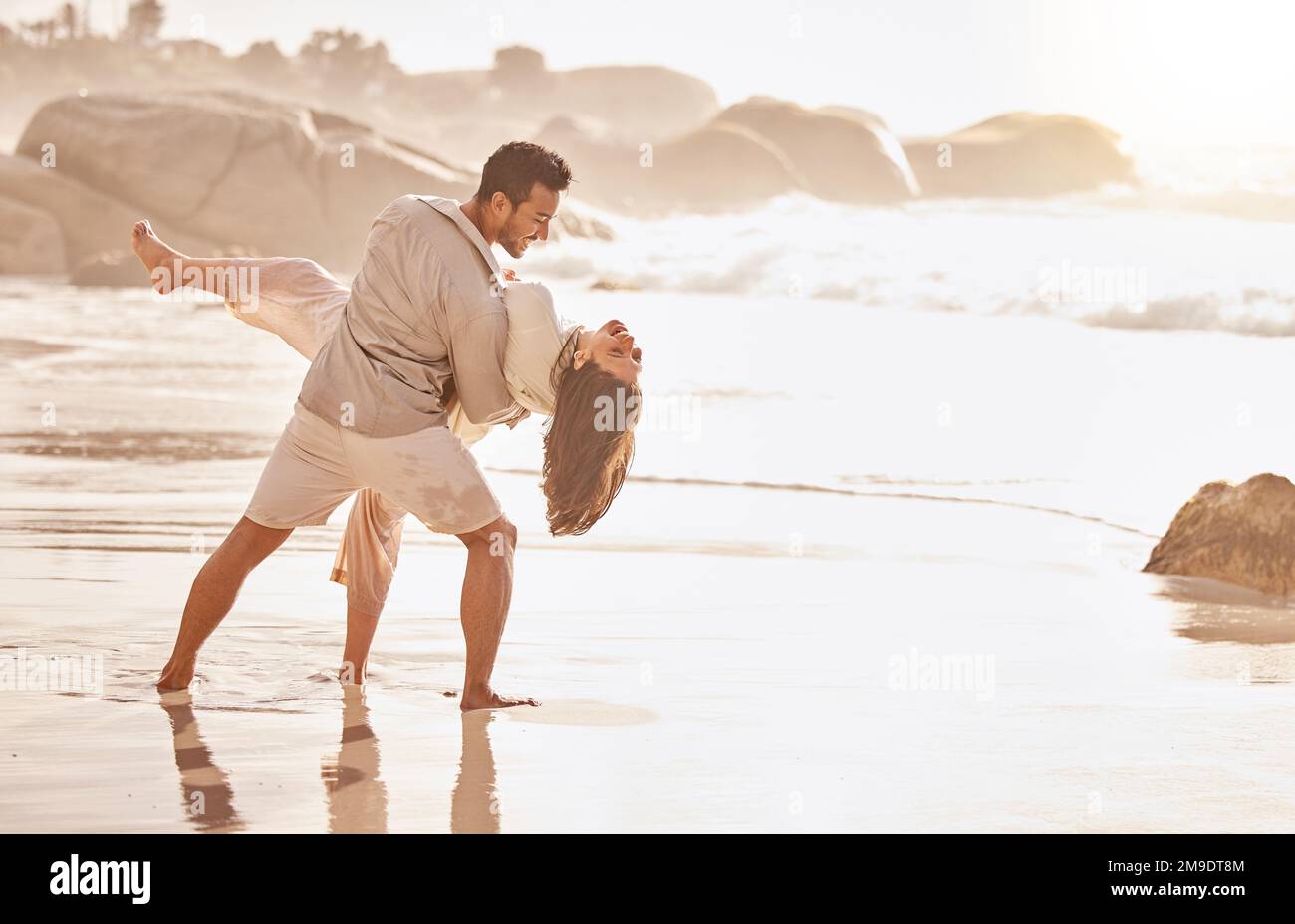 Du bist mein Tanzpartner für immer. Ein junges Paar, das am Strand tanzt. Stockfoto