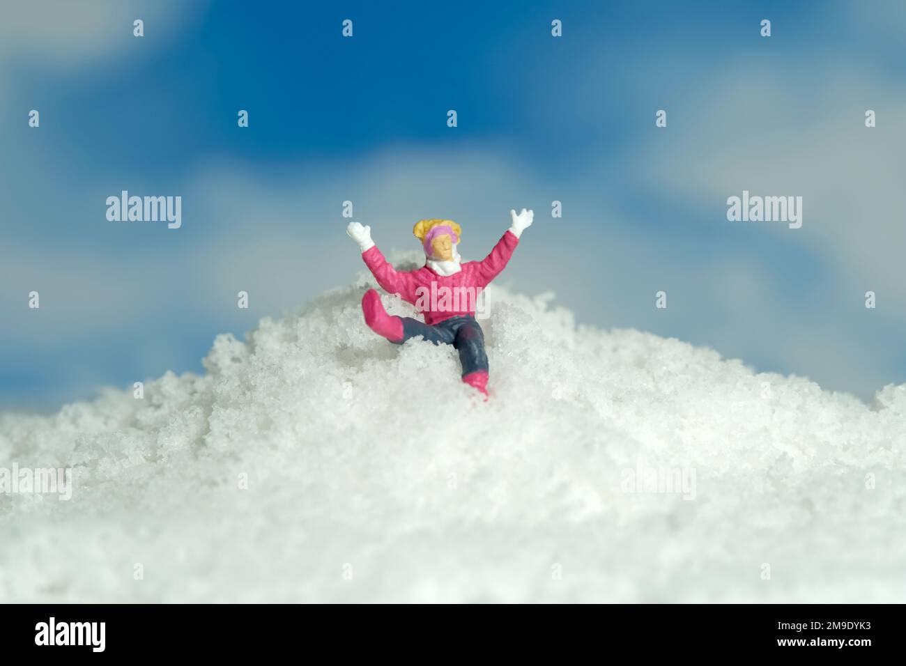 Miniatur-Menschen-Spielzeug-Figuren-Fotografie. Bergsteigen-Unfallsport. Eine Schneemeisterin, die in den schneebedeckten Berg fällt. Bildfoto Stockfoto