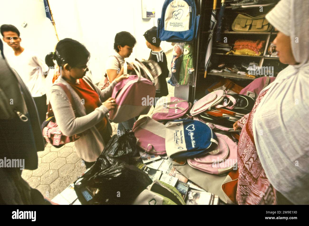 Kunden, die Optionen in einem Sackladen in der Nähe der Daarut Tauhiid-Moschee in Gegerkalong, Bandung, West Java, Indonesien, in Betracht ziehen. Daarut Tauhiid wurde vom berühmten indonesischen islamischen Prediger KH Abdullah Gymnastiar gegründet und konnte mit seiner Geschäftsleitung Manajemen Qolbu (MQ) den religiösen Tourismus und die wirtschaftlichen Aktivitäten im Gebiet Gegerkalong in Bandung-Stadt eskalieren lassen. Stockfoto