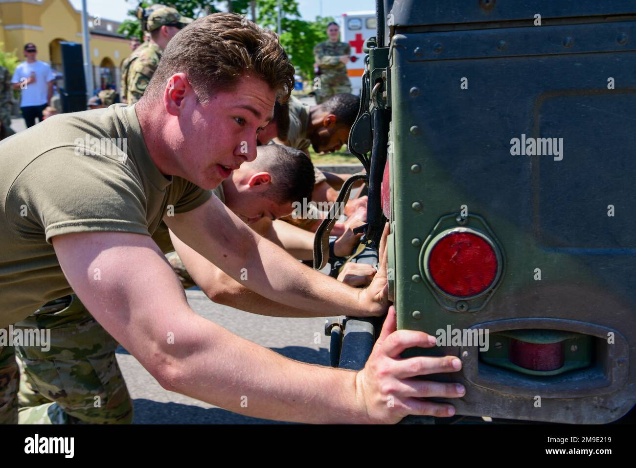 EIN US-AMERIKANISCHER Air Force Airman, der dem 31. Sicherheitsgeschwader zugeteilt wurde, schiebt mit seinem Team während eines Guns and Showwwettbewerbs am Aviano Air Base, Italien, am 18. Mai 2022 einen Humvee. Die SFS 31. konkurrierte gegen die Feuerwehr des Bauingenieurgeschwaders 31. in einem Hinderniskurs, der nach den Herausforderungen ihrer jeweiligen Aufgaben thematisiert wurde. Im Jahr 1962 erklärte Präsident Kennedy den Friedensoffizierstag zum Gedenktag am 15. Mai und erkannte den 15. Mai zur National Police Week an. Stockfoto