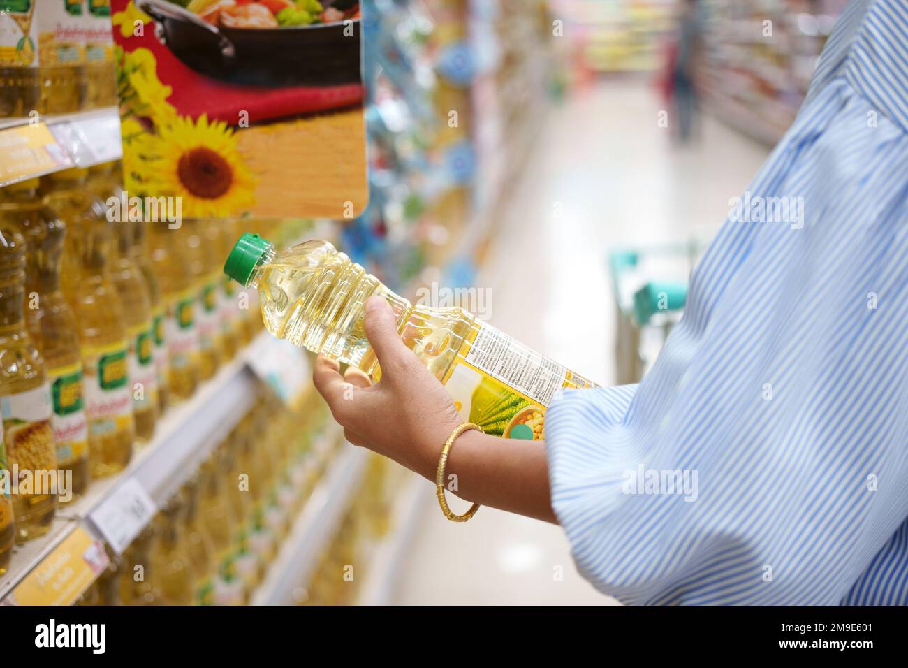 Eine Frau, die im Supermarkt Kochöl kauft. Stockfoto