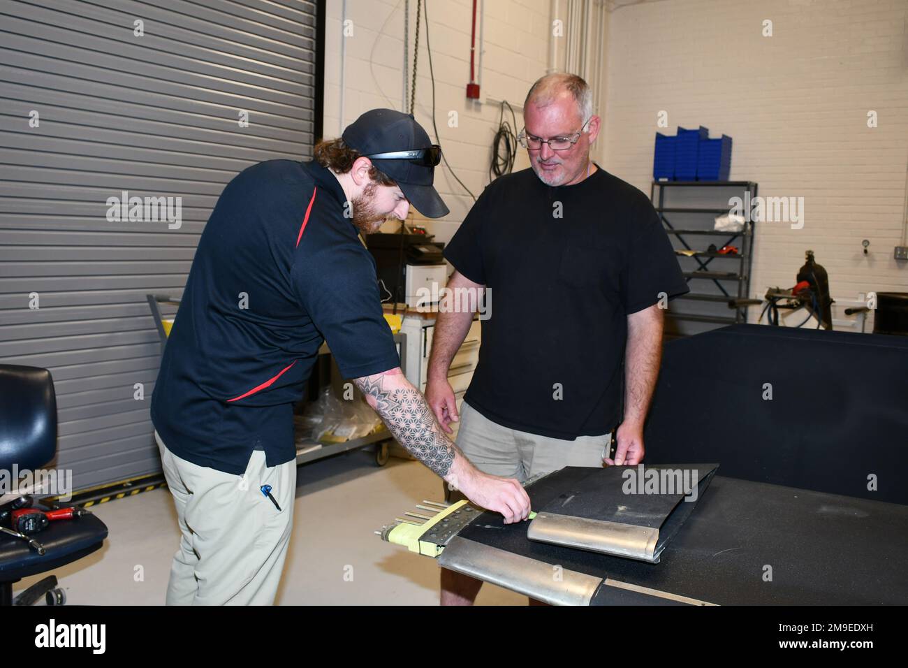 Joshua Peedin, Left, Senior Rotor Systems Engineer für das H-53 Fleet Support Team, und Robert Call, Work Leader für die Werkstatt für dynamische Komponenten, überprüfen die Gewichte, die zum Auswuchten einer H-53E Rotorschaufel verwendet werden. Fleet Readiness Center East verwendet die universelle statische Ausgleichsvorrichtung zum Auswuchten von Rotor und Heckscheiben für die Hubschrauber H-53E, V-22 und H-1. Das H-53K-Programm plant, die Vorrichtung auch zum Auswuchten der Schilde zu verwenden. (Foto: Kimberly Koonce, Fleet Readiness Center East) Stockfoto