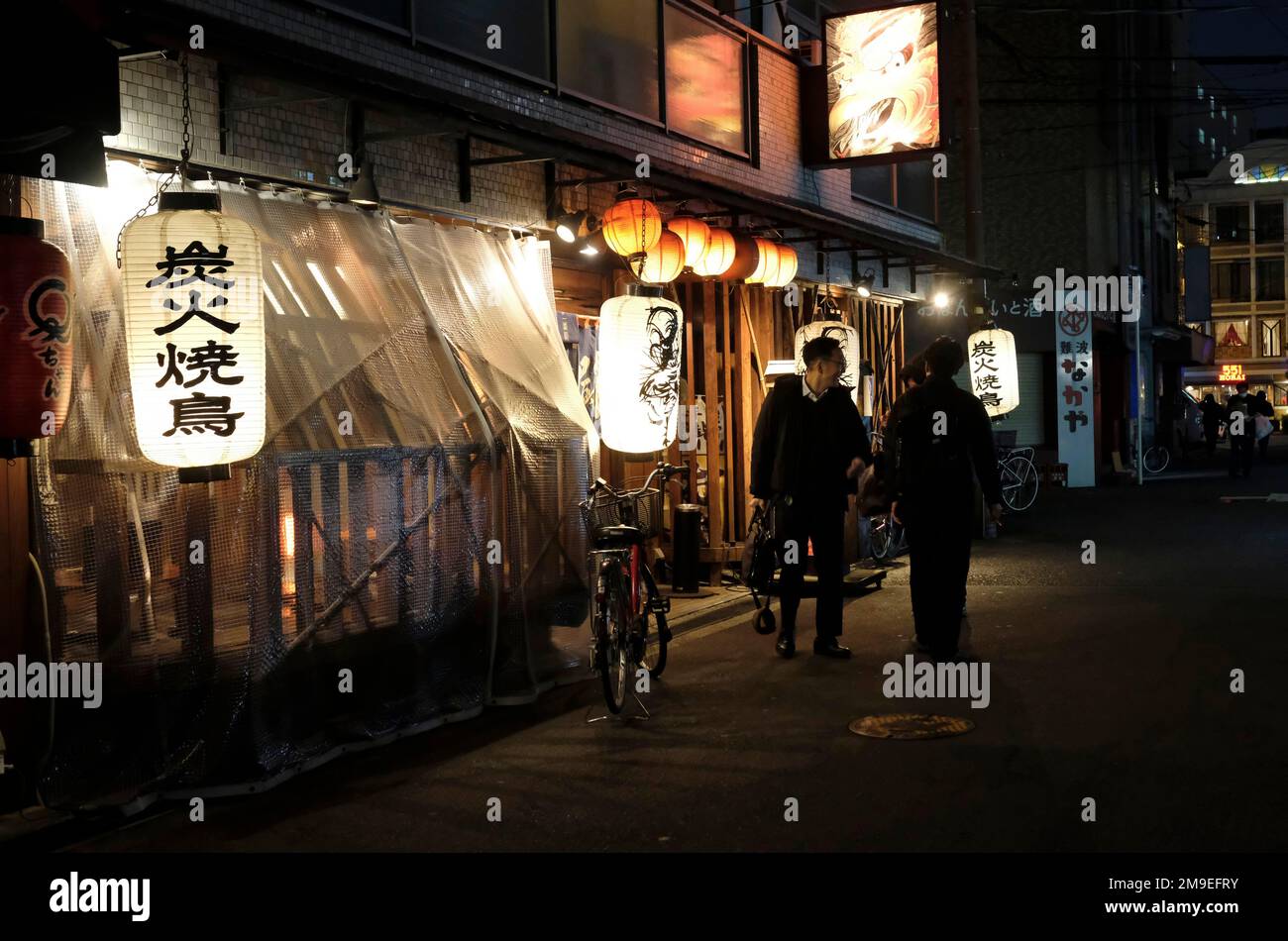 Tokio, Japan - 3. Januar 2023: In Tokio, Japan, treffen sich am späten Abend drei Personen vor einem Restaurant. Stockfoto
