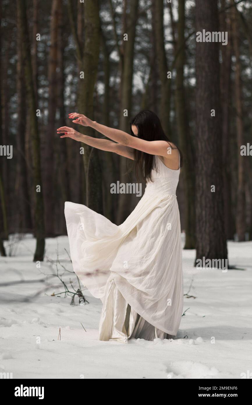 Geheimnisvolle Frau mit flatterndem weißen Kleidertuch auf windszenischer Fotografie Stockfoto