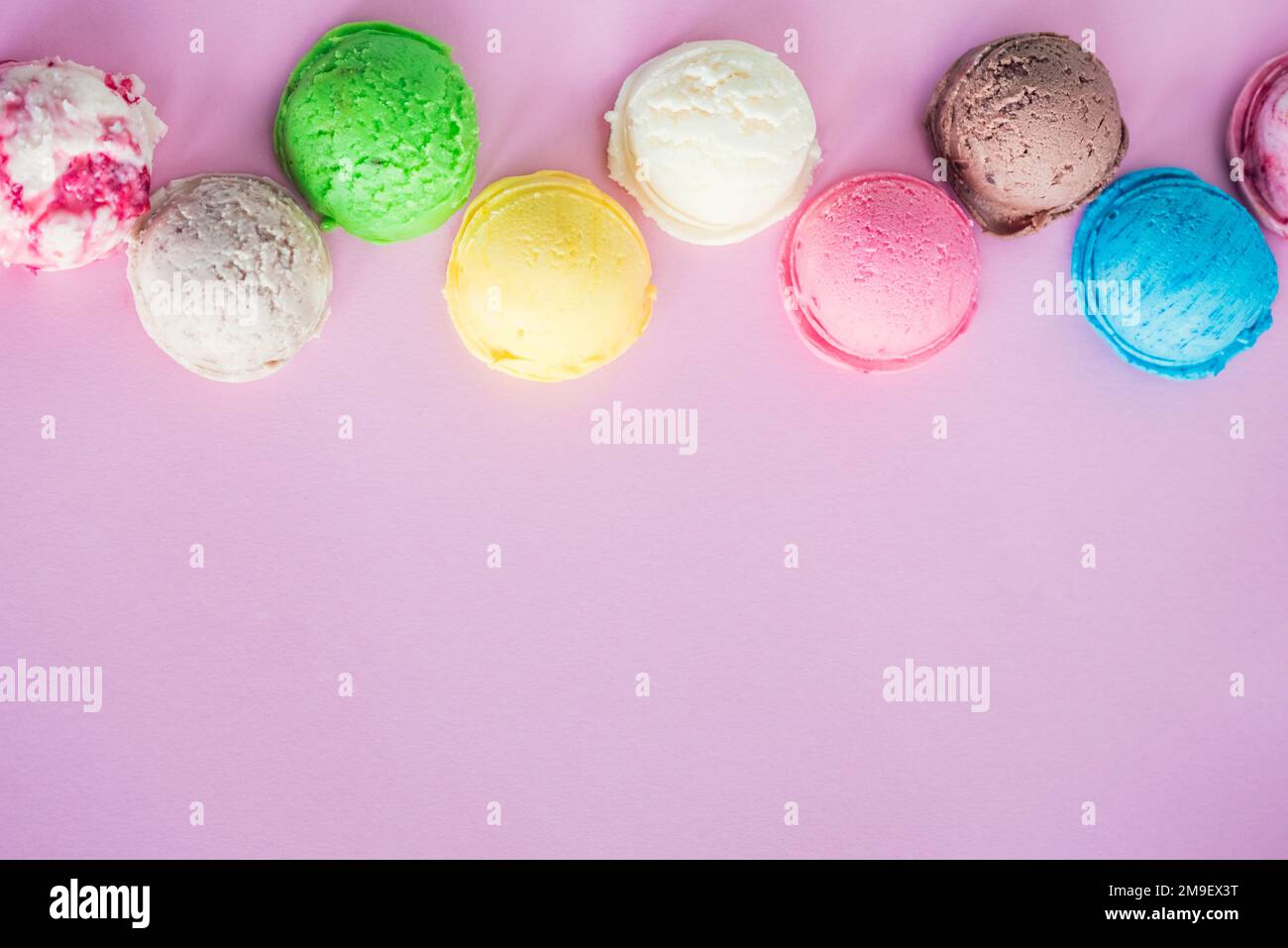 Bunte Eisschaufeln auf rosa Hintergrund mit Platz für Text. Speicherplatz kopieren. Stockfoto