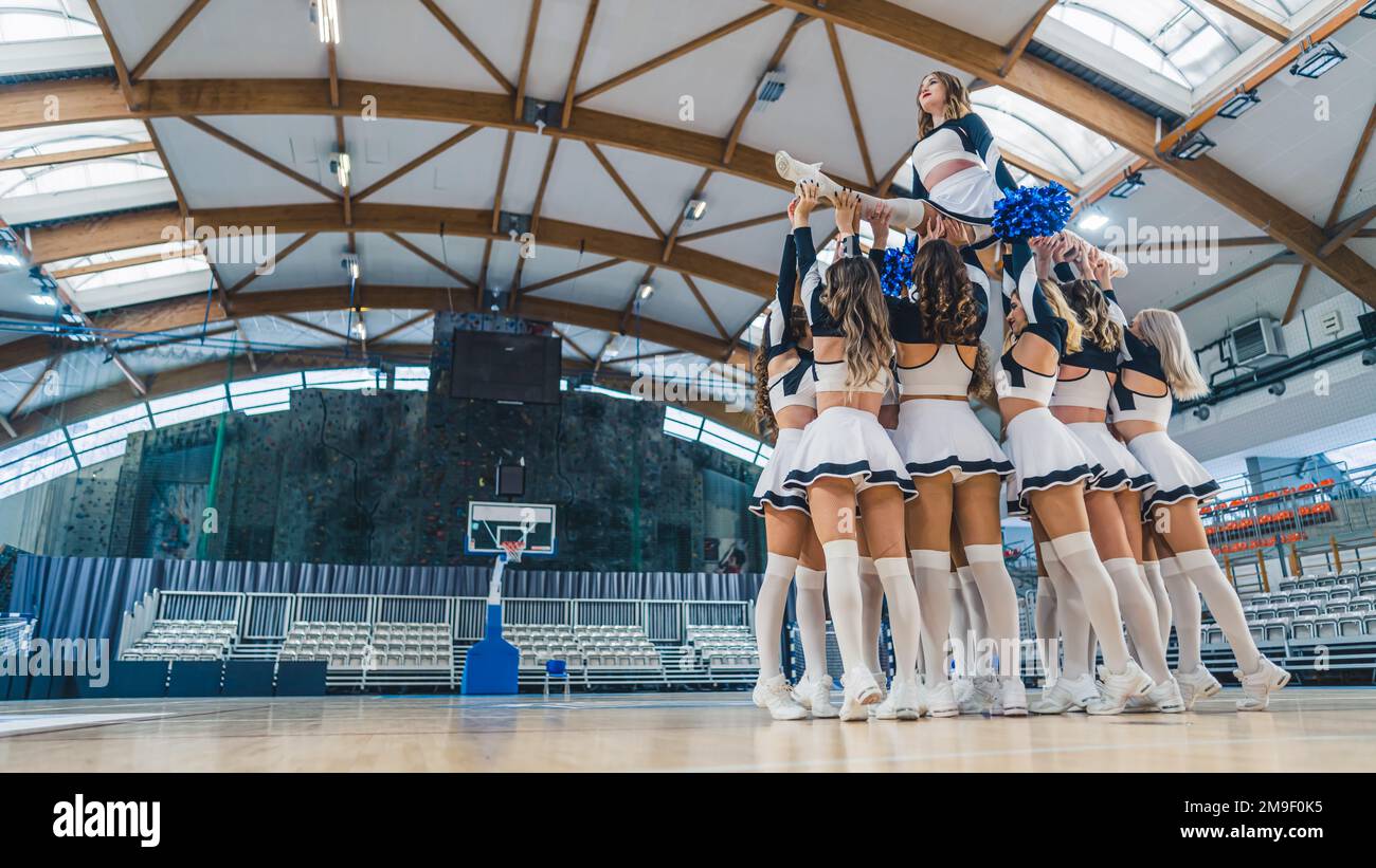 Ansicht von unten: Eine Gruppe von Cheerleader in weißen und ...