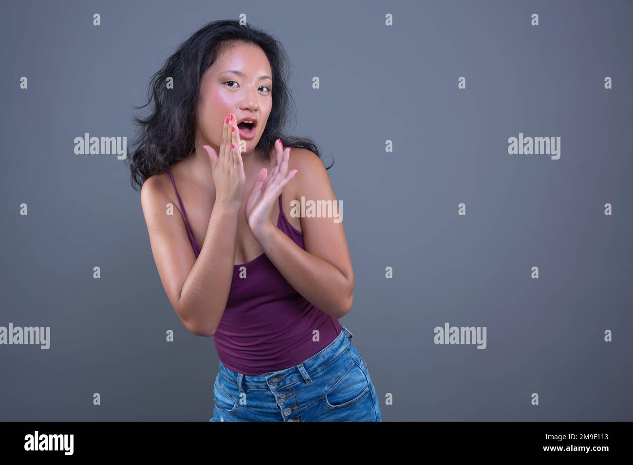 Junge asiatische Frau im Panzer-Top mit lustigem Ausdruck isoliert vom Hintergrund Stockfoto