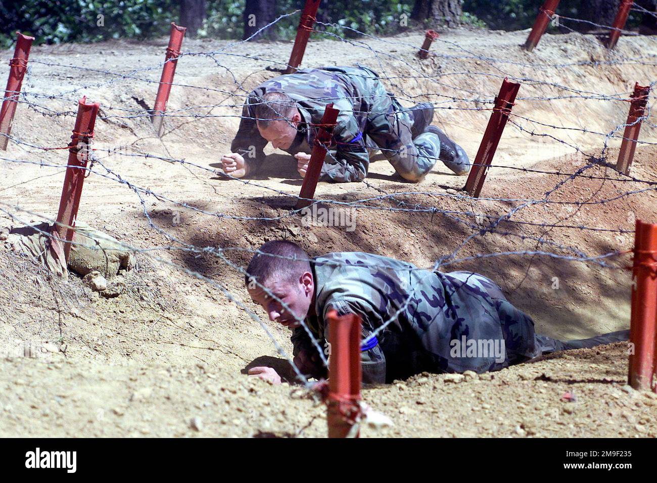 Linke Vorderansicht, mittlere Aufnahme, als US Air Force Techincal Sergeant Ronald Vickers und AIRMAN First Class Justin Lytwyn vom 305. Sicherheitsstaffel McGuire AFB, New Jersey, am 11. Mai im Tiefkriechbereich des Kampfausdauerkurses antreten, 2000 während des Wettbewerbs „Rodeo 2000 Readiness“. Während des einwöchigen Wettbewerbs waren mehr als 100 Teams und 2.500 Mitarbeiter von über 300 Air Force, Air Force Reserve, Air National Guard, USA Armeeeinheiten und fremde Nationen werden in den Bereichen Luftabwurf, Fracht, Tanken, Flugvorbereitung, Kampfausdauer, Kampftaktik und andere Luftkampftaktiken Stockfoto