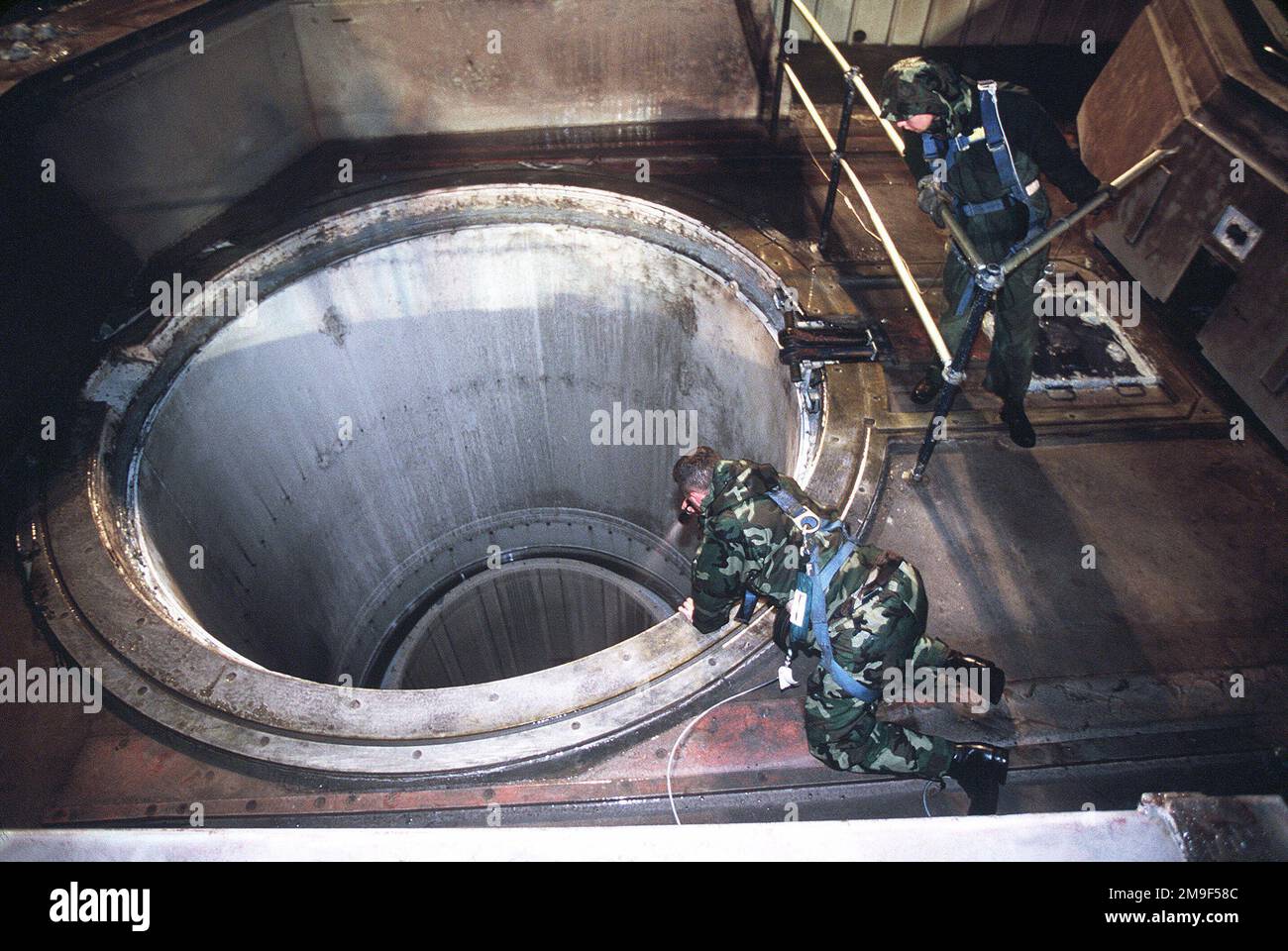 Das Wartungspersonal der US-Luftwaffe in einem Raketensilo der Friedenssicherungskräfte der Vandenberg AFB, CA, überprüft die Raketenrohre auf Schäden, die während des Starts aufgetreten sein könnten. Aus DEM AIRMAN Magazine, Juli 2000 Artikel "Peacekeeper 2000". Das Wartungspersonal der US-Luftwaffe in einem Raketensilo der Friedenssicherungskräfte der Vandenberg AFB, CA, überprüft die Raketenrohre auf Schäden, die während des Starts aufgetreten sein könnten. Aus dem Airman Magazine, Juli 2000 Artikel "Peacekeeper 2000". Stockfoto