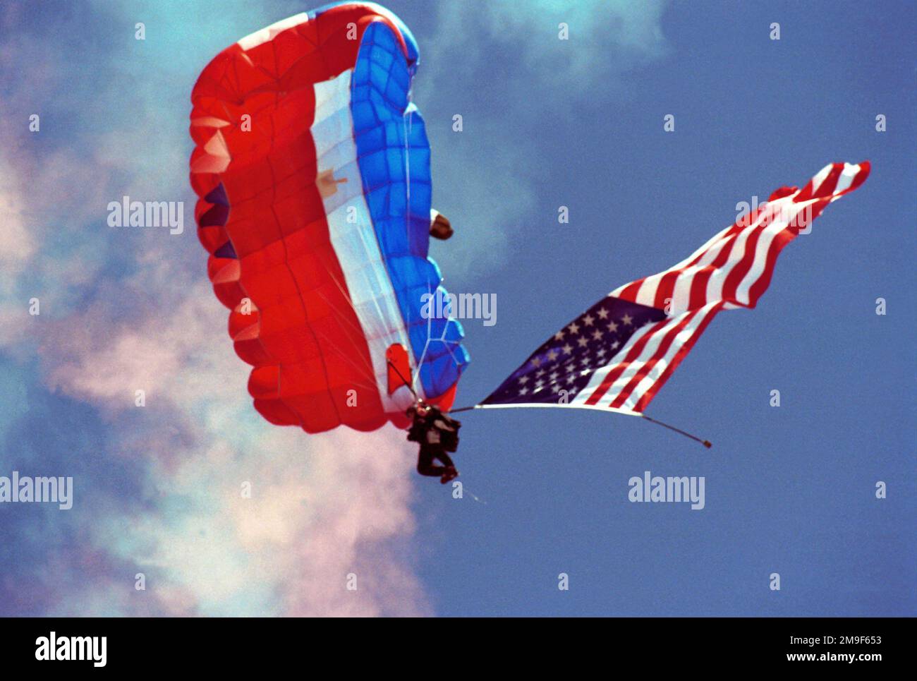 Ein Springer vom 22. Spezialtaktikgeschwader (STS), McChord Air Force Base, Washington, Fallschirmspringen aus einem C-23 Sherpa (nicht abgebildet) mit der Flagge der Vereinigten Staaten von Amerika für die Zeremonien auf der Klamath Falls Airshow 2000, Kingsley Field, Oregon Air National Guard Base, Klamath Falls, ODER am 18. Juli 2000. Basis: Kingsley Field Bundesstaat: Oregon (OR) Land: Vereinigte Staaten von Amerika (USA) Stockfoto