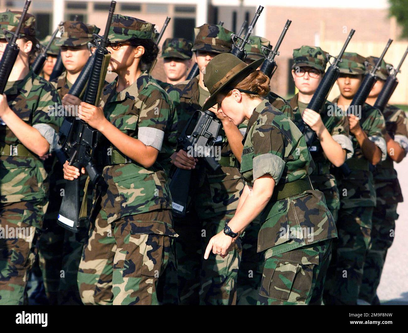 US Marine Platoon 4033 übt die Übung, während der 4. Bataillon Drill Instructor STAFF Sergeant Love (rechts, zeigt nach unten) ihre Bemühungen überwacht. Die Rekruten üben am 22. August 2000 auf dem 4. Bataillon Parade Deck, Marine Corps Recruit Depot, Parris Island, South Carolina. Basis: USMC Recruit Depot, Parris Island Bundesstaat: South Carolina (SC) Land: Vereinigte Staaten von Amerika (USA) Stockfoto
