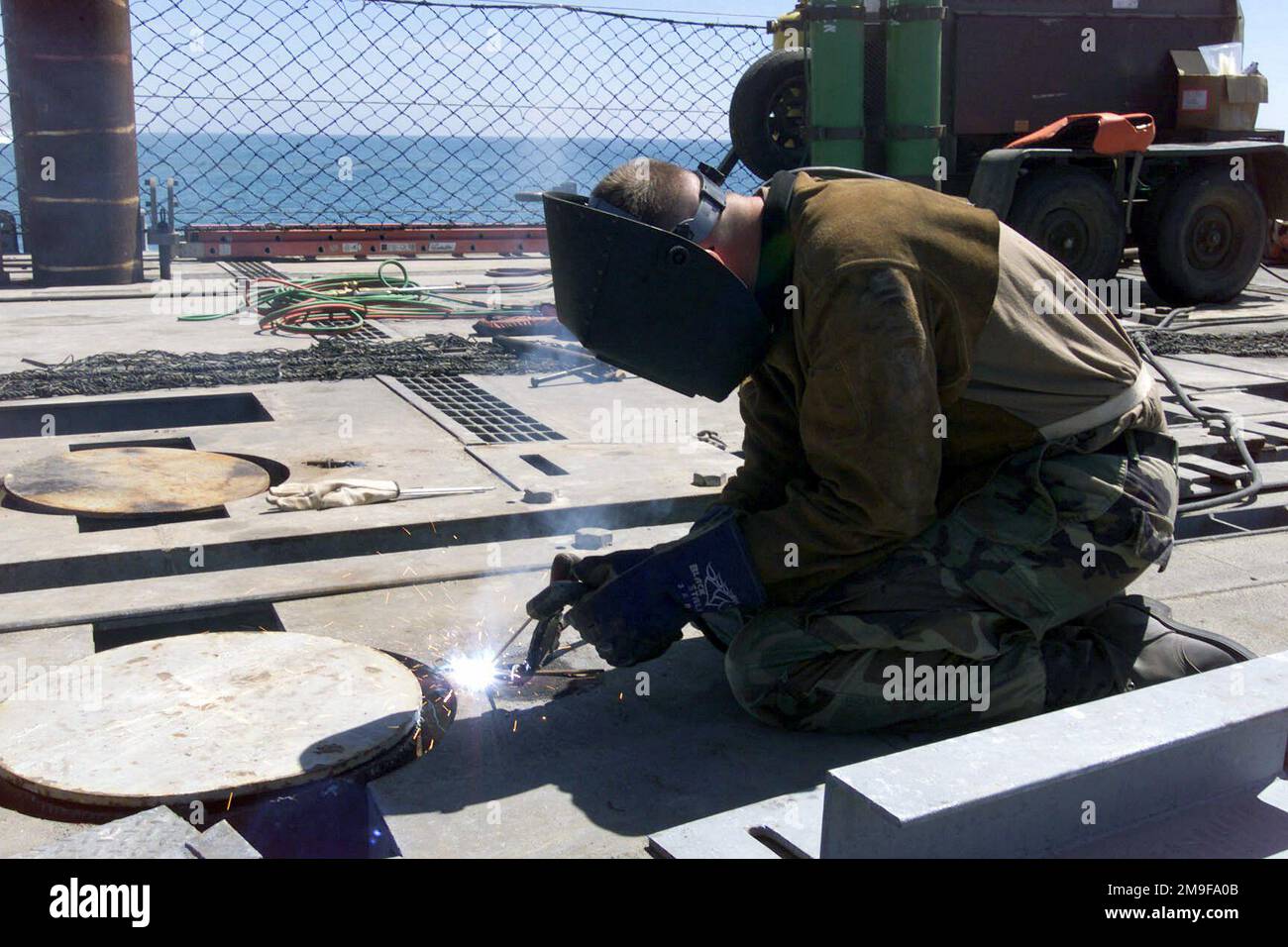 US Navy (USN) Steelworker Third Class (SW3) Charles Kelley, Amphibious Construction Battalion One (ACB-1), Naval Base Coronado, Kalifornien (CA), schweißt während der Übung TURBO PATRIOT, einer Joint Logistics Over-the-Shore (JLOTS) Übung, in Camp Pendleton, Kalifornien (CA) ein Gleitöse auf einen temporären Damm. Betreff Operation/Serie: TURBO PATRIOT Base: Marine Corps Base Camp Pendleton Bundesstaat: Kalifornien (CA) Land: Vereinigte Staaten von Amerika (USA) Stockfoto