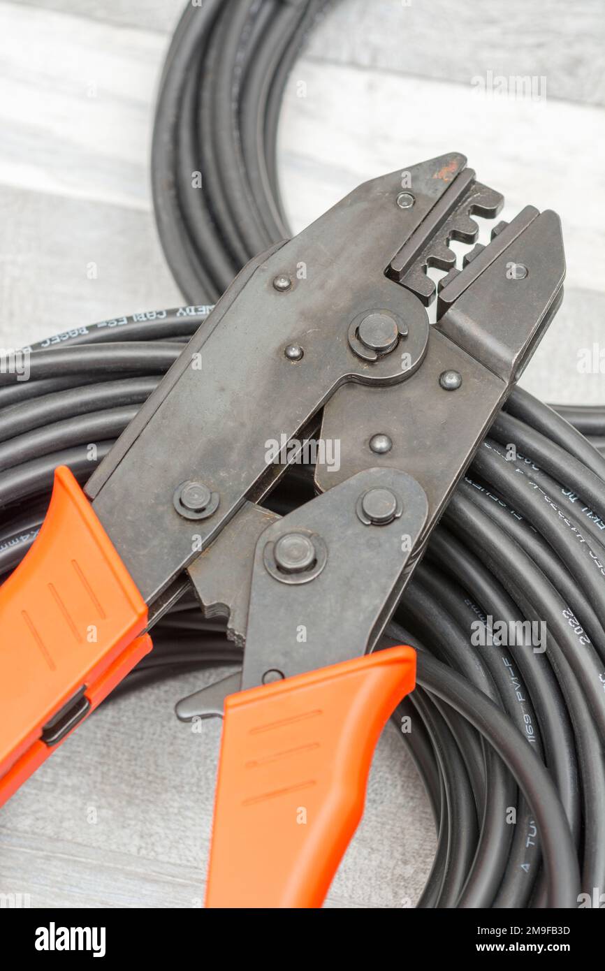 Nahaufnahme der Hand-Crimpzange für Solarsteckverbinder der Marke MC4 in China und der Solaranschlusskabel (mit der Marke 4mm² Elsewedy). Stockfoto