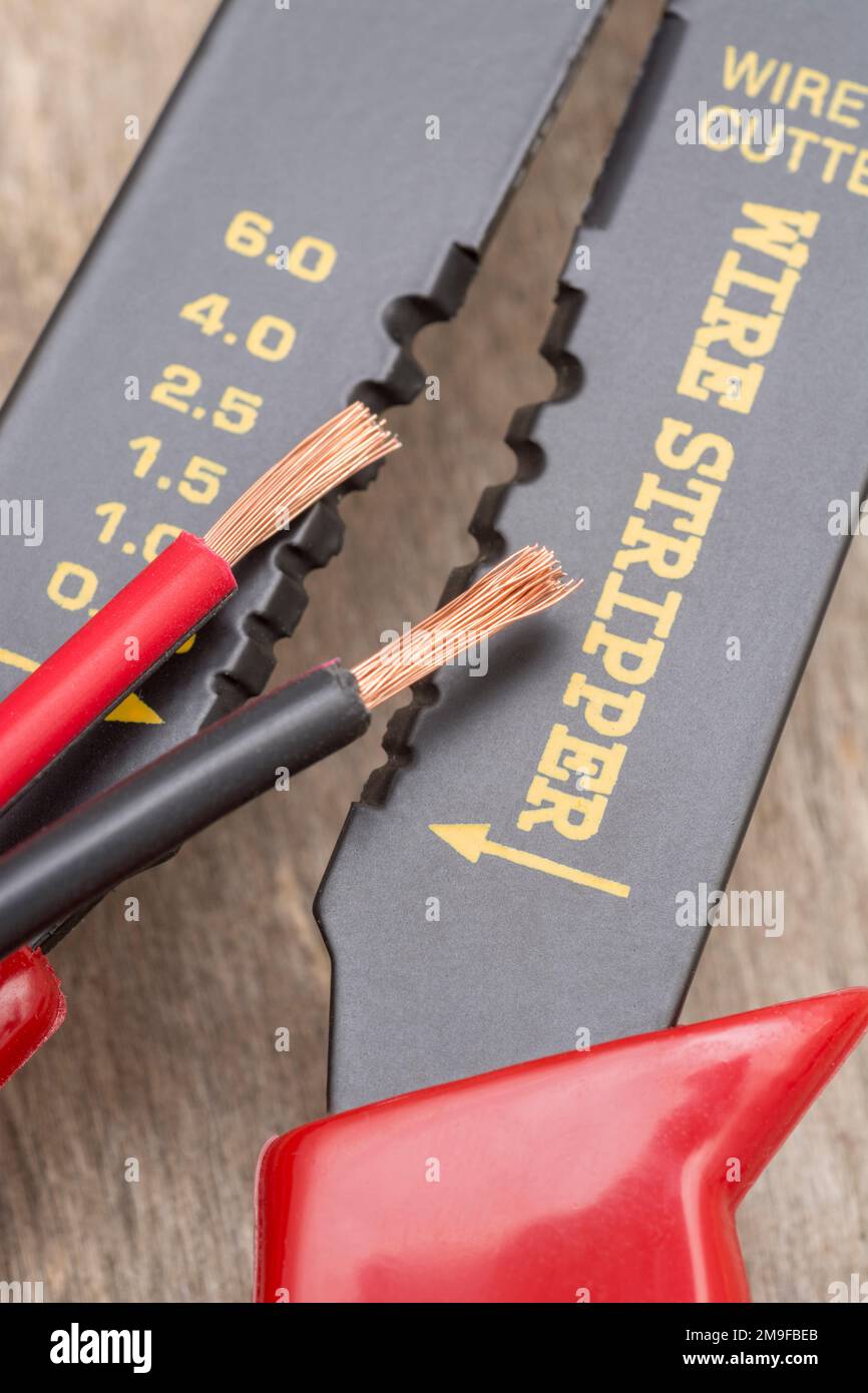 Nahaufnahme des in China hergestellten Abisolierers und Drahtschneiders ohne Markenkennzeichnung für 26-10AWG-Draht (siehe Hinweise) mit abisolierten Steckverbinderdrähten. Stockfoto