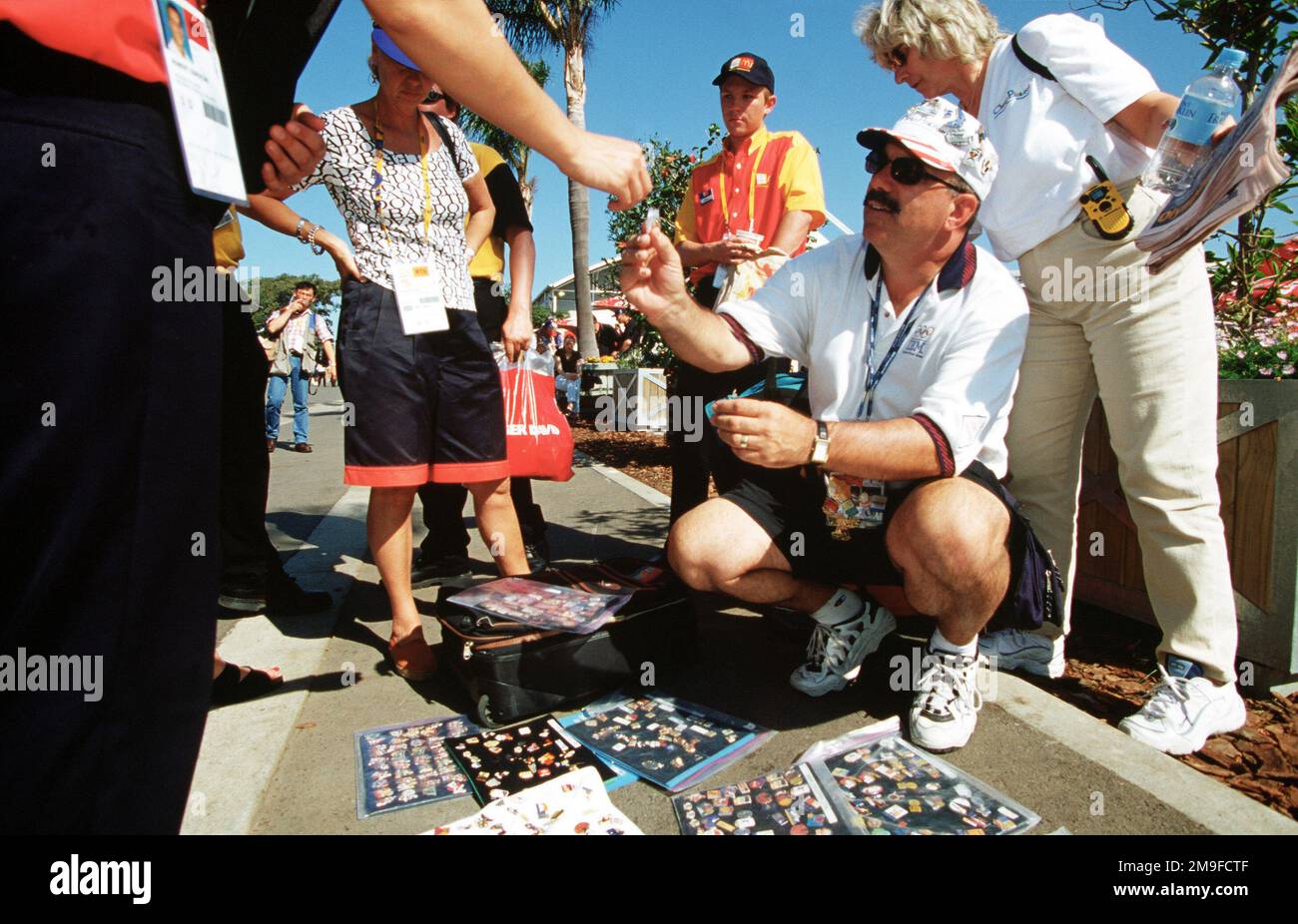 Der amerikanische Bob McKeon aus Poway, Kalifornien (kniend), sagte, die Olympiade in Sydney sei sein siebter. McKeon, ein begeisterter Nadelhändler und Sammler, sagt, dass er 20.000 seiner 100.000-Pin-Kollektion während der Olympischen Spiele 2000 in sydney zum Handel mitgebracht hat. Zahlreiche Mitarbeiter des US-Verteidigungsministeriums (nicht abgebildet) nehmen an den Olympischen Spielen Teil, von Trainern und Hilfspersonal bis hin zu Sportlern, die an verschiedenen Veranstaltungsorten teilnehmen. Basis: Sydney Staat: New South Wales Land: Australien (AUS) Stockfoto