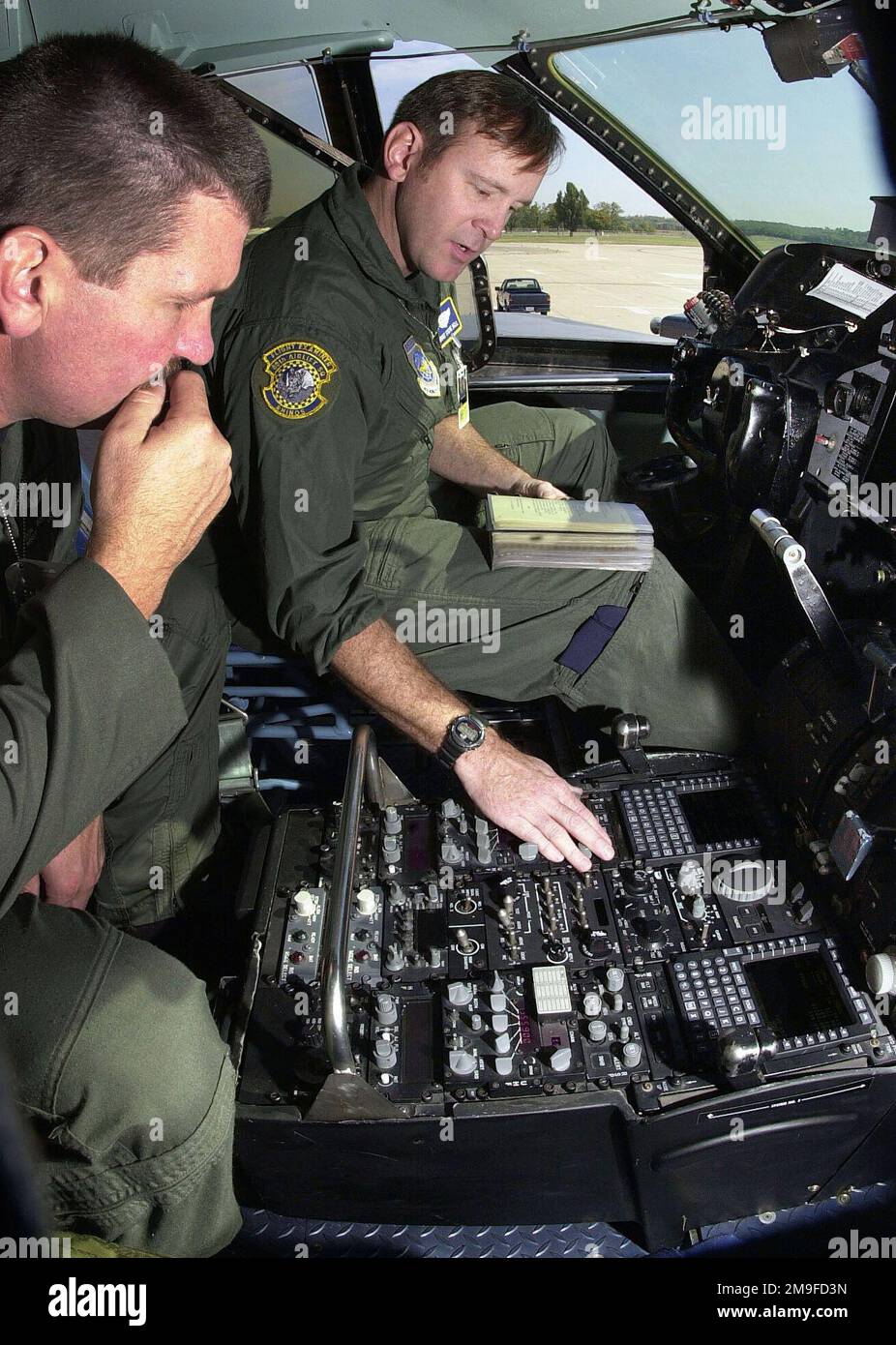 US Air Force SENIOR MASTER Sergeant Steve Bell (rechts) informiert USAF MASTER Sergeant DIN Boudinet über den Betrieb des Flight Management System (FMS) Display Unit in einem C-141C Starlifter Flugzeug der 89. Airlift Squadron (USAFR), Wright-Patterson Air Force Base, Ohio. Das FMS ist nur eine von mehreren wichtigen Änderungen, mit denen die „Glass Cockpit“-Technologie in mehr als sechzig Flugzeugen der aktuellen C-141B-Flotte eingeführt wird. Jedes Gerät erhält die All Weather Flight Control System, bestehend aus einem digitalen Autopiloten, einer fortschrittlichen Avionik-Anzeige und einem System zur Vermeidung von Bodenunfällen. Anderer Major Stockfoto
