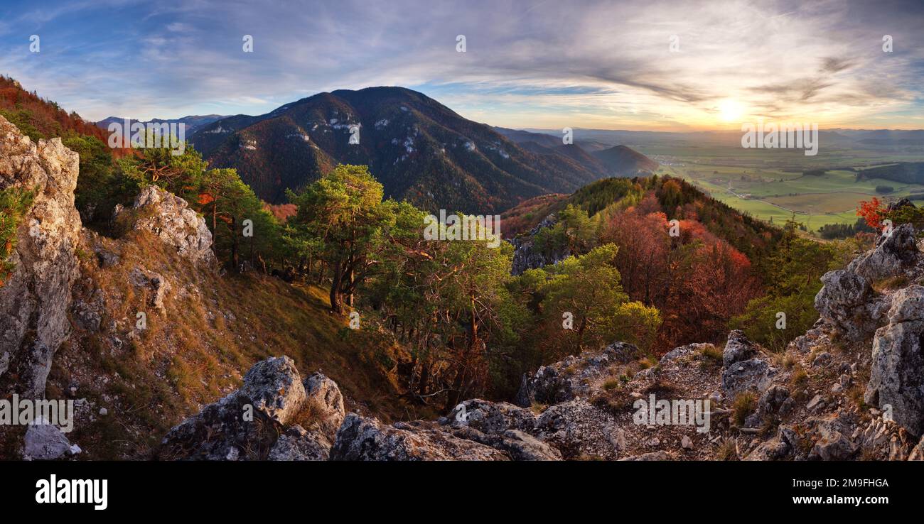 Panorama der Berge. Alles gelbes Licht der Sonne. Der Himmel wunderschöne rote Wolken Stockfoto