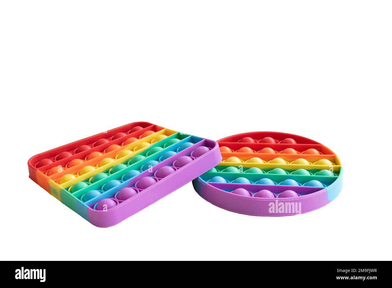 Zwei unterschiedlich geformte, regenbogenfarbene Knöpfe. Ein sensorisches Spielzeug mit Blasenfieder, isoliert auf weißem Hintergrund. Stockfoto