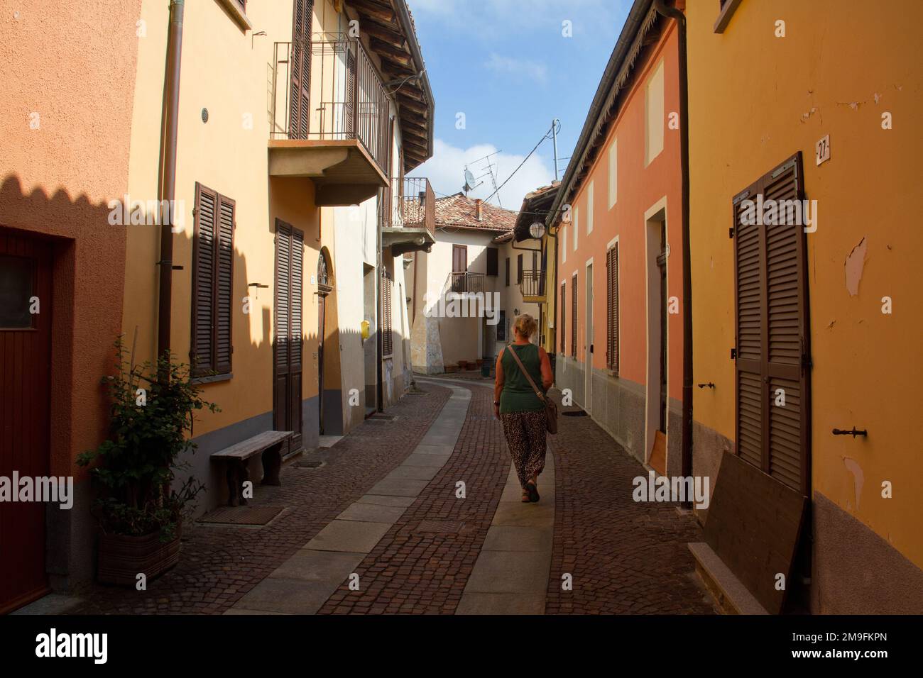 Weibliche Touristen, die durch eine ruhige, typisch toskanische Straße in Italien laufen Stockfoto