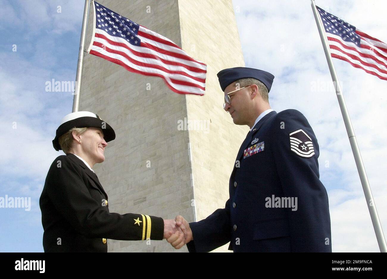 Vor dem Hintergrund des Washington Monument entsandte US Air Force MASTER Sergeant Michael A. Reed aus dem 367. Training Support Squadron, Hill Air Force Base, Utah, als Mitglied des Einführungskomitees der Streitkräfte (AFIC), Offiziell wieder in die Luftwaffe aufgenommen von US Navy Reservist Lieutenant Junior Grade Lola Britton in Washington, D.C. Das 2001. Einführungskomitee der Streitkräfte (AFIC) führt eine mehr als 200 Jahre alte Tradition für die Amtseinführung des Präsidenten 54. fort, in der der neue Oberbefehlshaber geehrt und die zivile Kontrolle über das Militär anerkannt wird. AFIC ist ein gemeinsamer Serviceorganisator Stockfoto