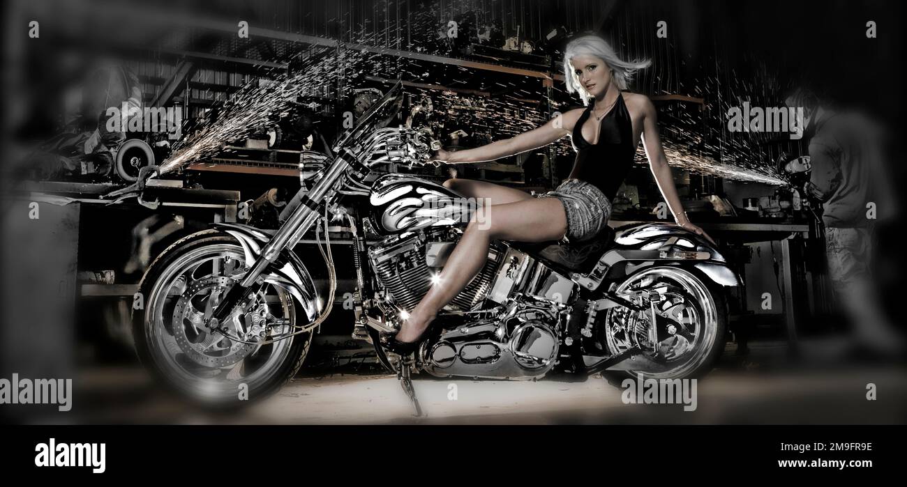 Weibliches Modell mit einem Motorrad in einer Werkstatt Stockfoto