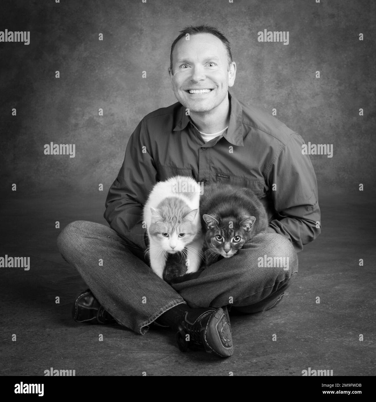 Studio Portrait von lächelnden Mann mit zwei Katzen. Stockfoto