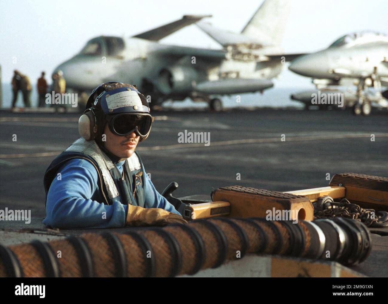 Mit S-3B Viking-Flugzeugen im Hintergrund ist der US Navy AIRMAN Apprentice Eric Martinez auf einem Traktor zwischen dem Abschleppen und Entkeilen von Flugzeugen während des Starts auf dem Cockpit der USS HARRY S. TRUMAN (CVN 75). Truman ist auf Station im Persischen Golf, um die Operation SÜDWACHE zu unterstützen. Betreff Betrieb/Serie: SÜDLICHE WACHSTATION: USS Harry S. Truman (CVN 75) Stockfoto