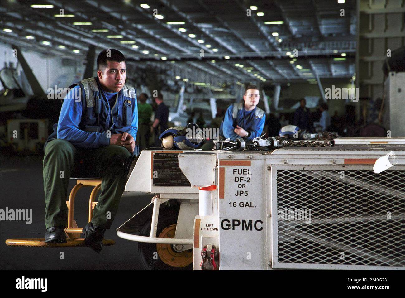 DER FLUGZEUGFÜHRER Alex Banda und DER FLUGZEUGFÜHRER Bryn Hunter nehmen sich einen Moment Zeit, um sich auf einem Transportwagen und Bodengeräten in der Hangarbucht der USS Harry S. Truman (CVN 75) zu entspannen, bevor sie am Ende des Flugbetriebs das Flugzeug bewegen. TRUMAN ist auf Station im Arabischen Golf zur Unterstützung der Operation SOUTHERN WACHE. SOUTHERN WATCH errichtet eine südliche Flugverbotszone über dem Irak und erstreckt sich bis zu den Grenzen südlich von Bagdad, der irakischen Hauptstadt. Betreff Betrieb/Serie: SÜDLICHE WACHSTATION: USS Harry S. Truman (CVN 75) Stockfoto