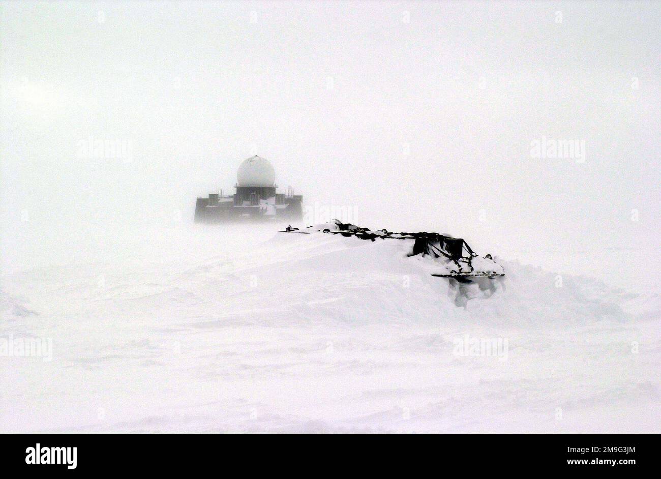 Die Mitglieder der Arctic Airlift Wing (AW) Arctic Aircraft Recovery School (auch bekannt als „Kool School“) von 109. werden diese schneegebundenen Gerätepaletten zurückholen. Im Hintergrund befindet sich ein verlassener Early Warning Radar Site, ein Teil des früheren DEW-Systems (Distant Early Warning). Die Schule befindet sich auf der Eiskappe Grönlands, nur drei Meilen von der verlassenen FÄRBEFLÄCHE II entfernt. Betreff Operation/Serie: TIEFKÜHL 2001 Basis: Kangerlussuaq Staat: Westgrönland Land: Grönland (GRL) Szene Hauptkommando gezeigt: AMC Stockfoto