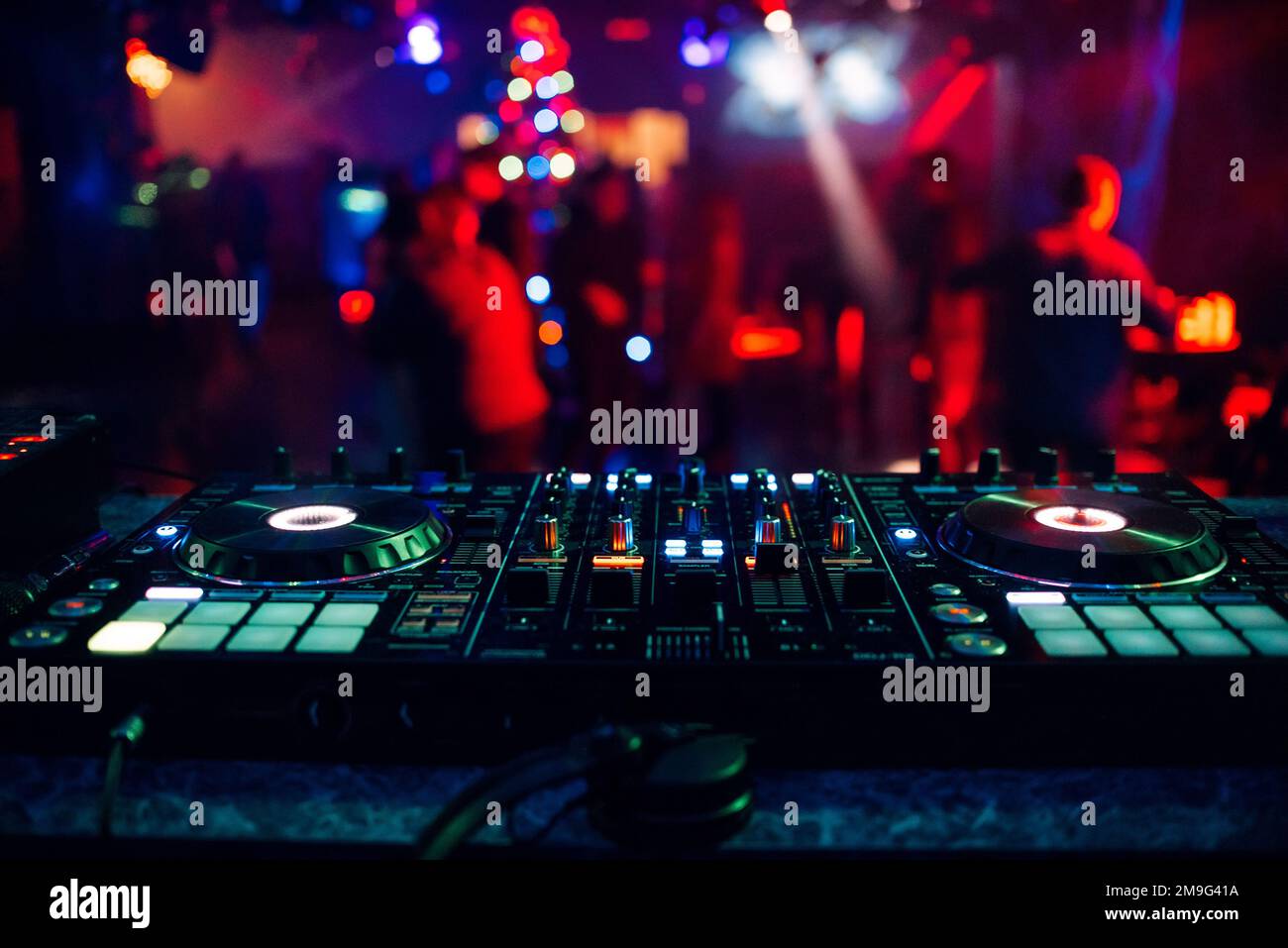 DJ Mixer Controller Board zum Mischen von Musik in einem Nachtclub auf einer Party mit heller Farbbeleuchtung Stockfoto
