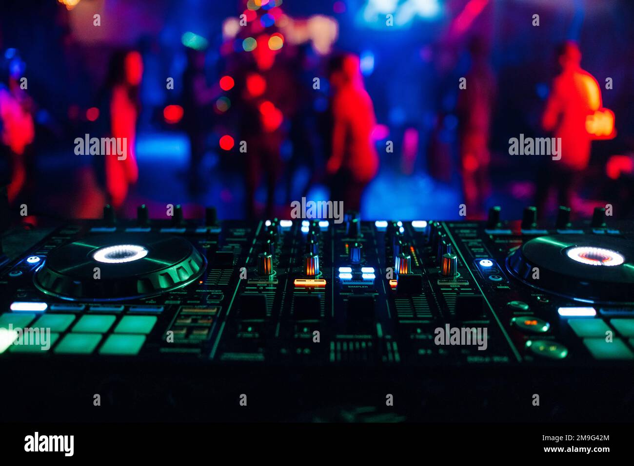 DJ Mixer Controller Board zum Mischen von Musik in einem Nachtclub auf einer Party mit heller Farbbeleuchtung Stockfoto