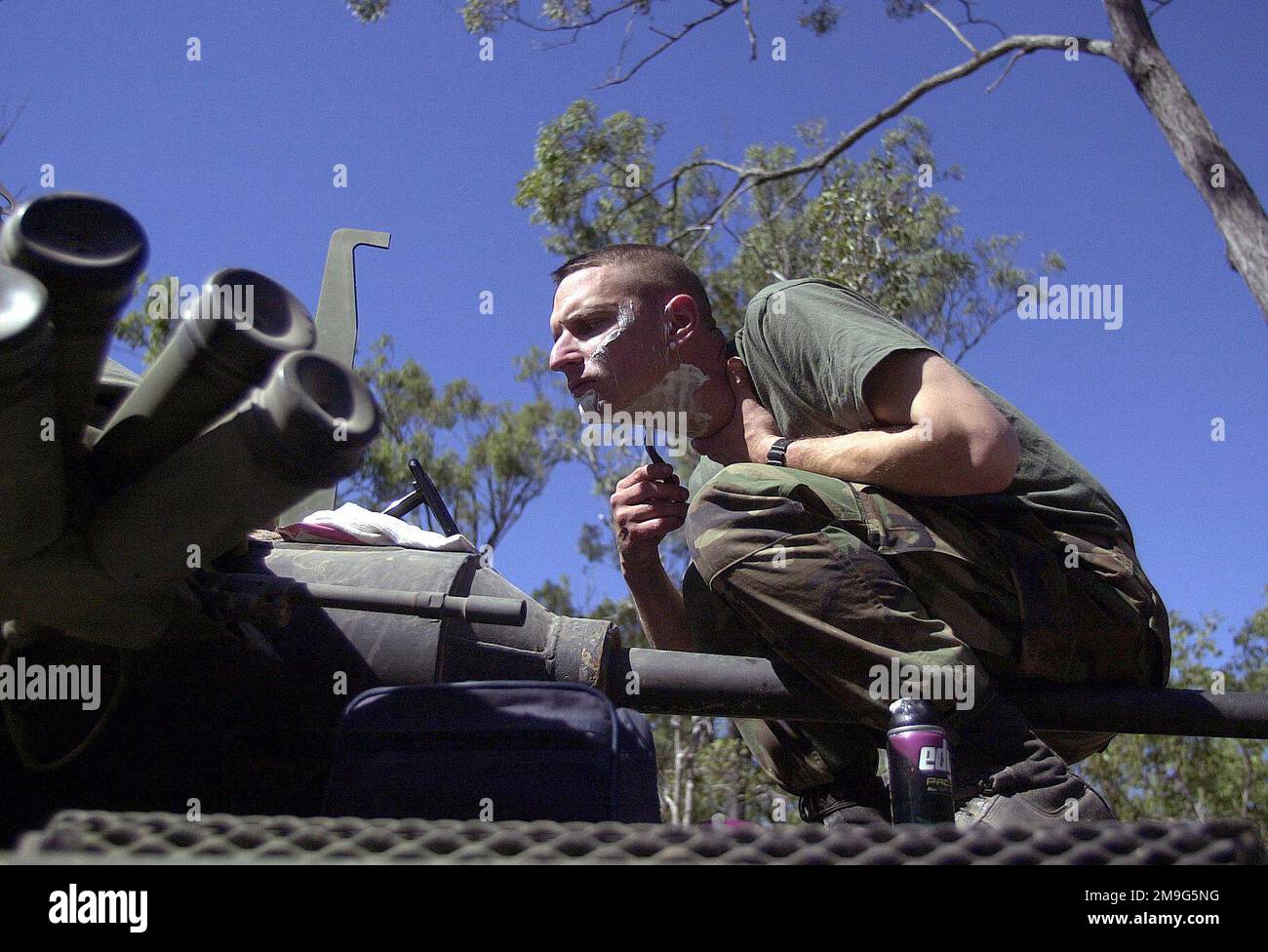 010520-F-1644L-006. [Complete] Szene Caption: Springing the Barrel of the M242 25mm Chain gun, Company MASTER GUNNER, Sergeant David Trogolo, USMC, Delta Company, 4. Light Armor Reconnaissance (LAR), Quantico, Virginia, nimmt sich die Zeit, um an Bord eines Light Armored Vehicle-25 (LAV-25) einige persönliche Hygiene einzuholen, nachdem er tagelang während des TANDEM-Trainings auf dem Feld gelebt hat. Die Mission des 4. LAR ist es, verschiedene Kontrollpunkte zu patrouillieren, jeden Feind anzugreifen und ihn auf die Hauptstreitkräfte zu schieben. Die LAR verdeckt die Bewegung der Hauptkraft, indem sie ihre Flanken und Abschirmungen schützt. Sie werden für Inf kämpfen Stockfoto