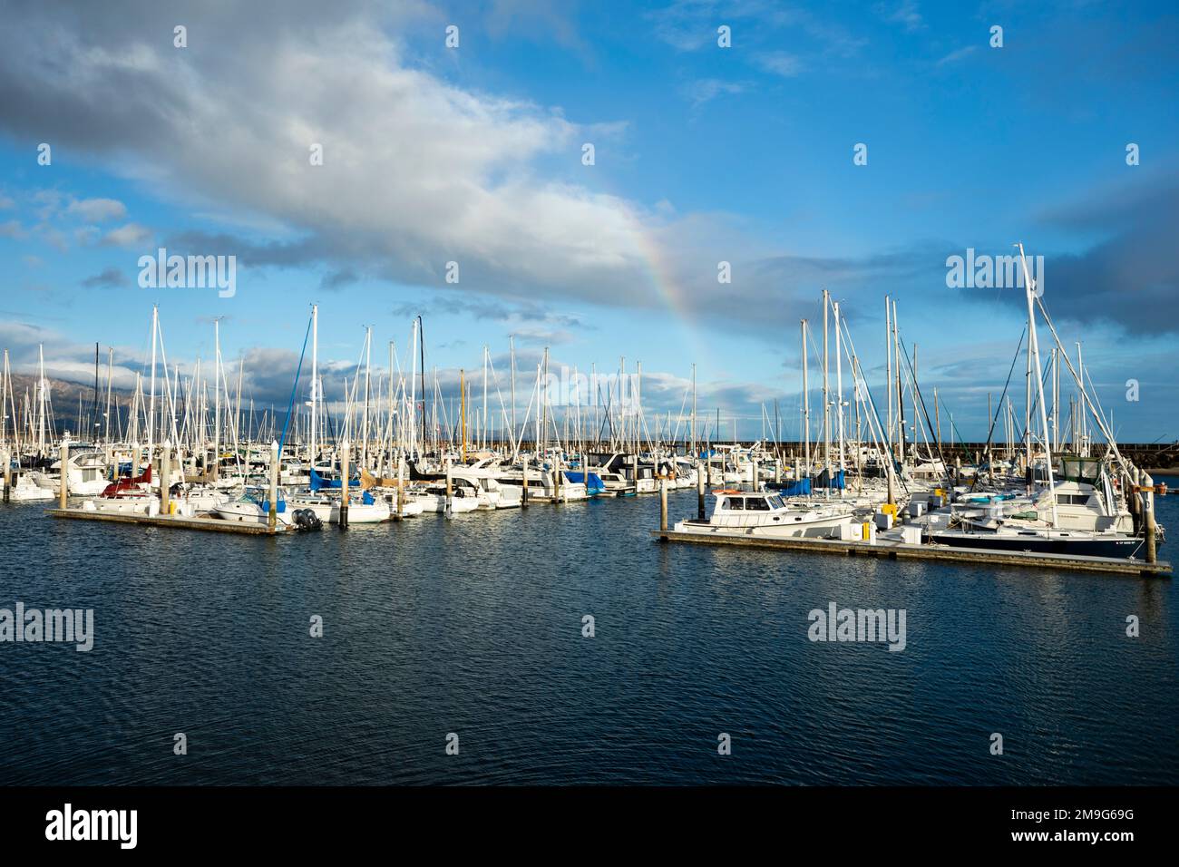 Regenbogen über einer großen Anzahl von Yachten, die im Hafen in Santa Barbara, Kalifornien, USA, vor Anker liegen Stockfoto