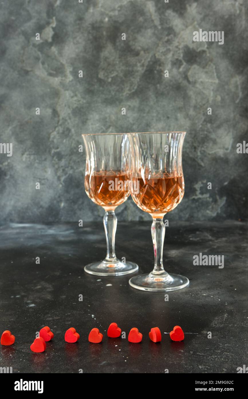 Zwei Gläser Schnaps und kleine rote Herzen, schwarzer Hintergrund Stockfoto