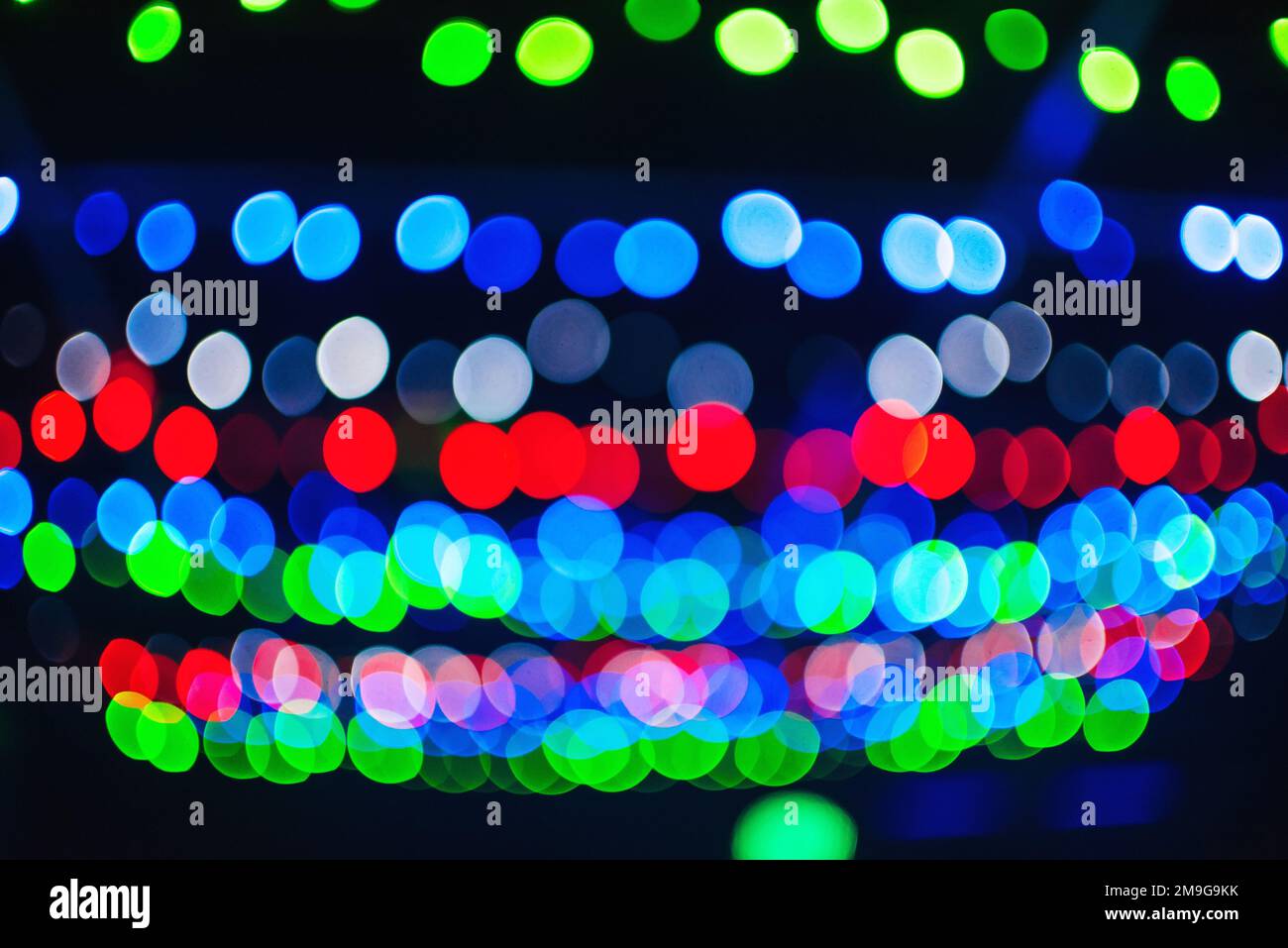 Farbenfroher abstrakter Hintergrund mit rundem Bokeh aus den hellen Lichtern der Weihnachtsgirlande Stockfoto