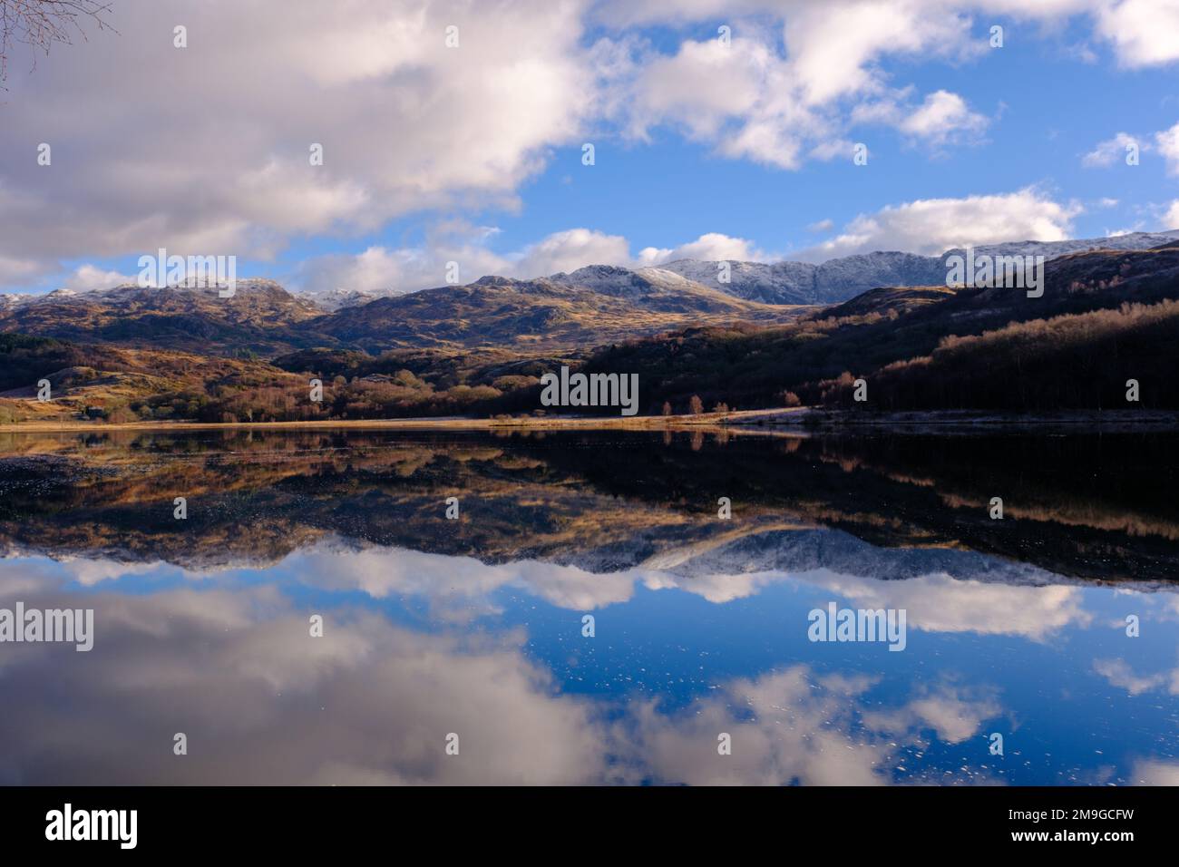 Perfekte Reflexion schneebedeckter Berge in einem See im Snowdonia-Nationalpark, Nordwales Stockfoto