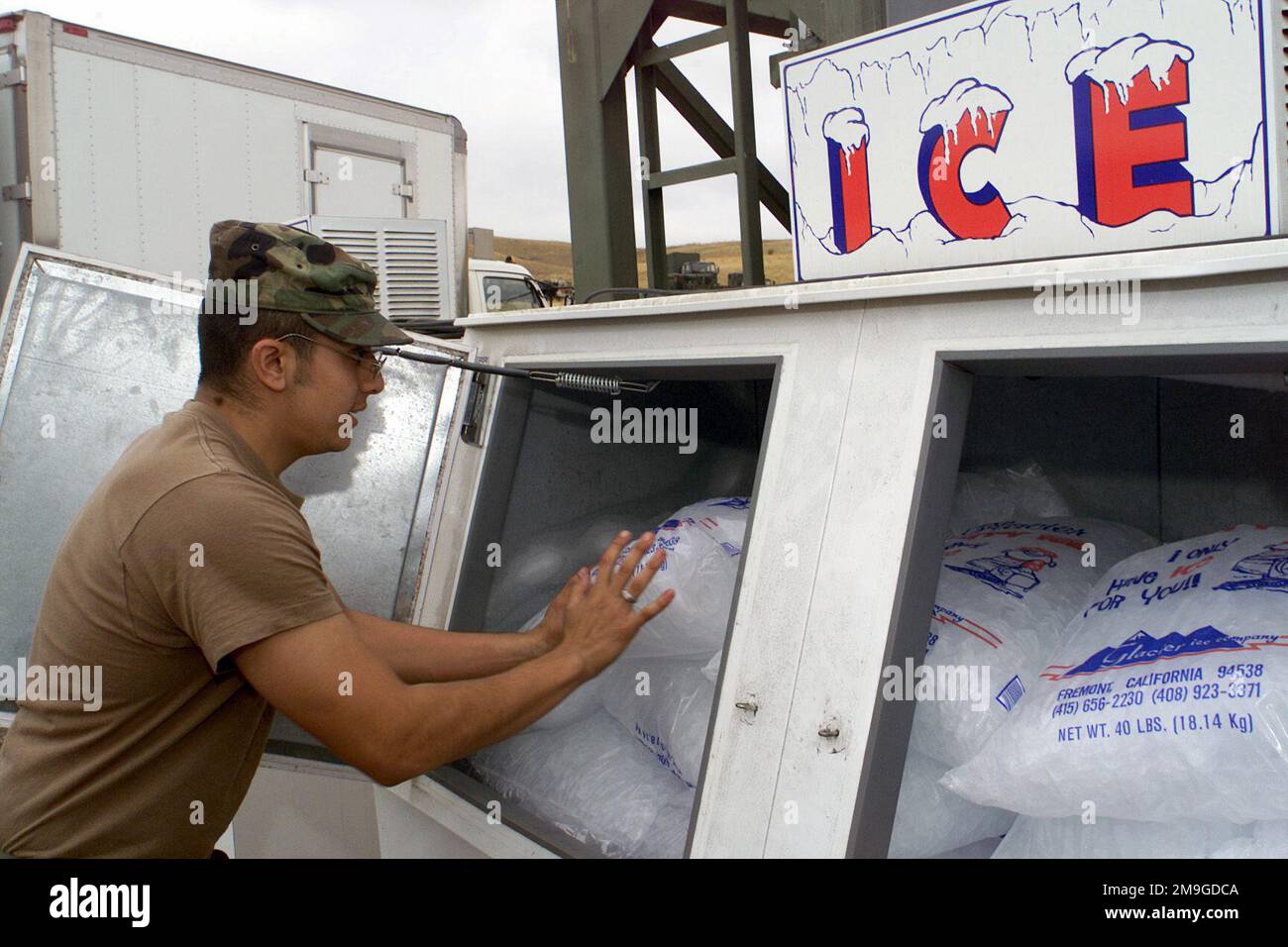 Private Oscar Sanchez, 437. Medical Company, Los Alamitos, Kalifornien, lädt Eis, Für Lebensmittel und medizinische Zwecke, in einen Gefrierschrank während des Betriebs GOLDEN MEDIC 2001. Reservetruppen aus dem ganzen Land nehmen an GOLDEN MEDIC Teil, einer medizinischen Feldübung mit mehreren Einheiten, die im Park Reserve Forces Training Area, Dublin, Kalifornien, stattfindet, in der die Armee simulierte Opfer von der Frontlinie durch verschiedene Stadien in ein Hauptzelt transportiert. Betreff Betrieb/Serie: GOLDEN MEDIC 2001 Basis: Camp Dublin Staat: Kalifornien (CA) Land: Vereinigte Staaten von Amerika (USA) Stockfoto