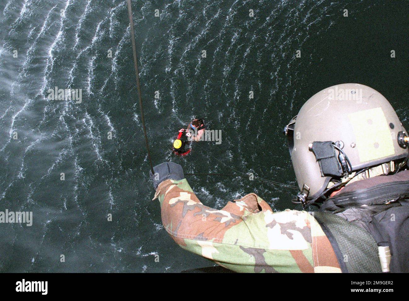 Der Windenbetreiber an Bord des MH-47E Chinook Helikopters von Company 'B', 2. Battalion 160. Special Operations Aviation Regiment, Ft Campbell, Kentucky, bereitet sich darauf vor, ein Mitglied der Flugbesatzung während einer Wasserrettungsübung am Lake Michigan, Milwaukee, Wisconsin, aus dem 128. Air Tanken Flügel zu heben. Im Wasser überwacht und überprüft ein Sicherheitslehrer, ob das Besatzungsmitglied sicher am Eindringkörper befestigt ist. Die Veranstaltung ist Teil der Übung WHITETAIL 2001. Betreff Operation/Serie: WHITETAIL 2001 Base: Lake Michigan State: Wisconsin (WI) Country: United States of America (USA) Scene Major Command gezeigt: AN Stockfoto